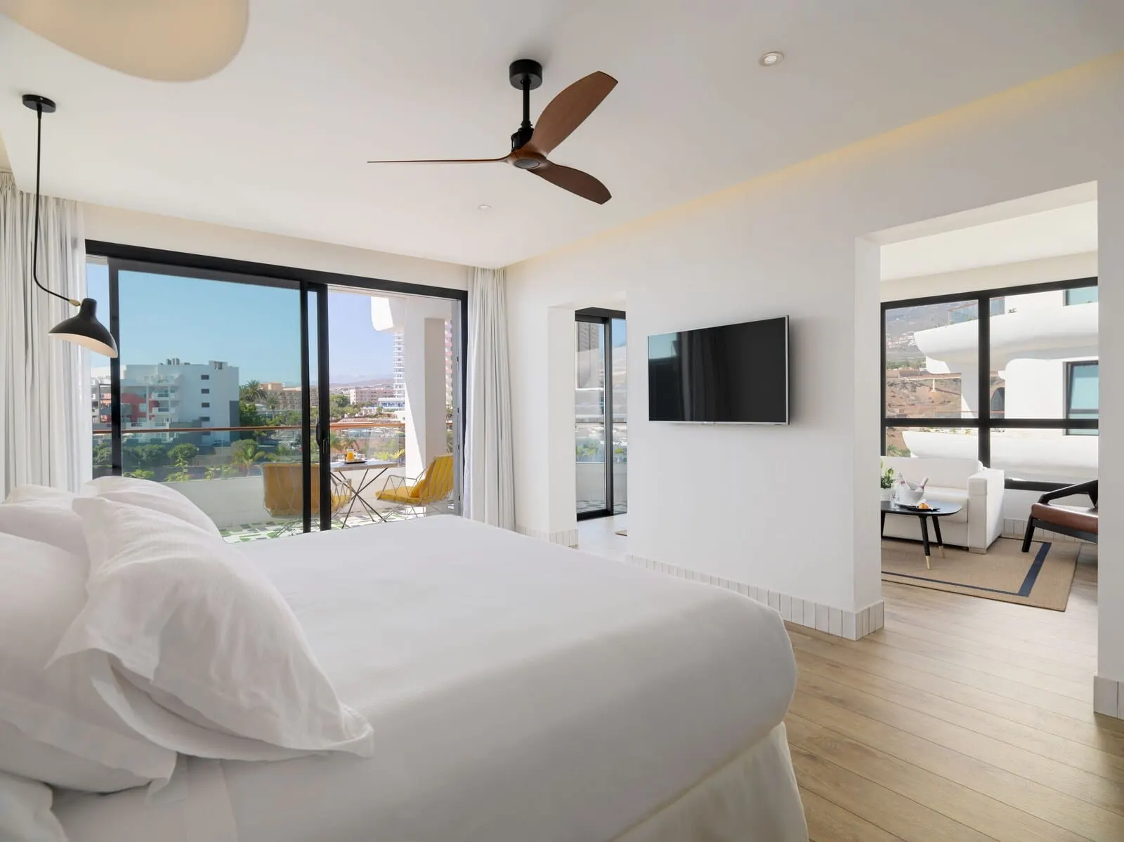 H10 Atlantic Sunset: A modern hotel room with a large bed, a ceiling fan, a TV mounted on the wall