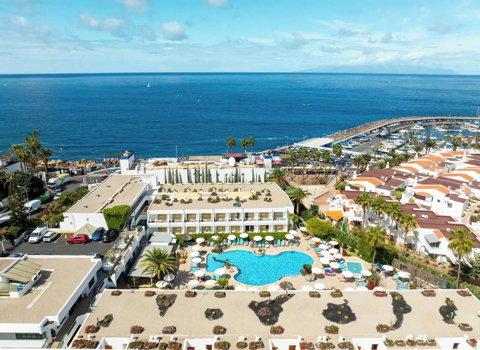 HOVIMA Panorama: A resort with a swimming pool, beach area, and ocean view