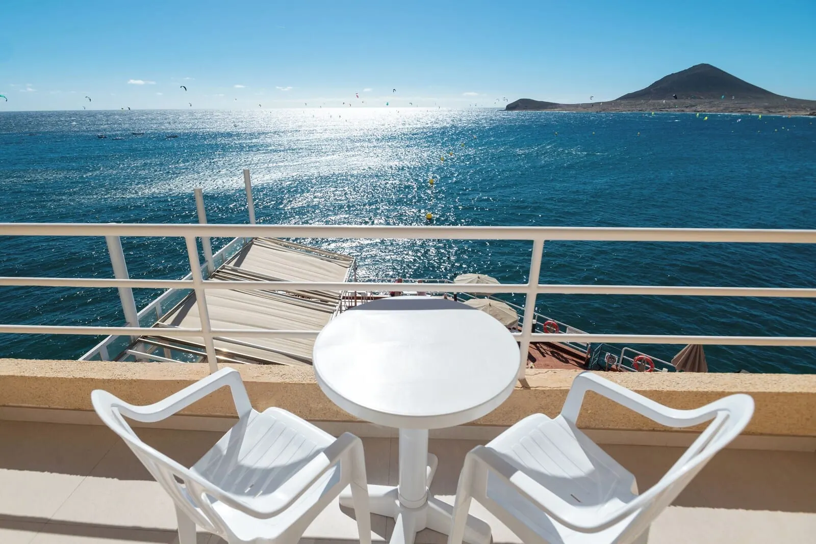 Médano Hotel: A balcony with a white table and two white chairs
