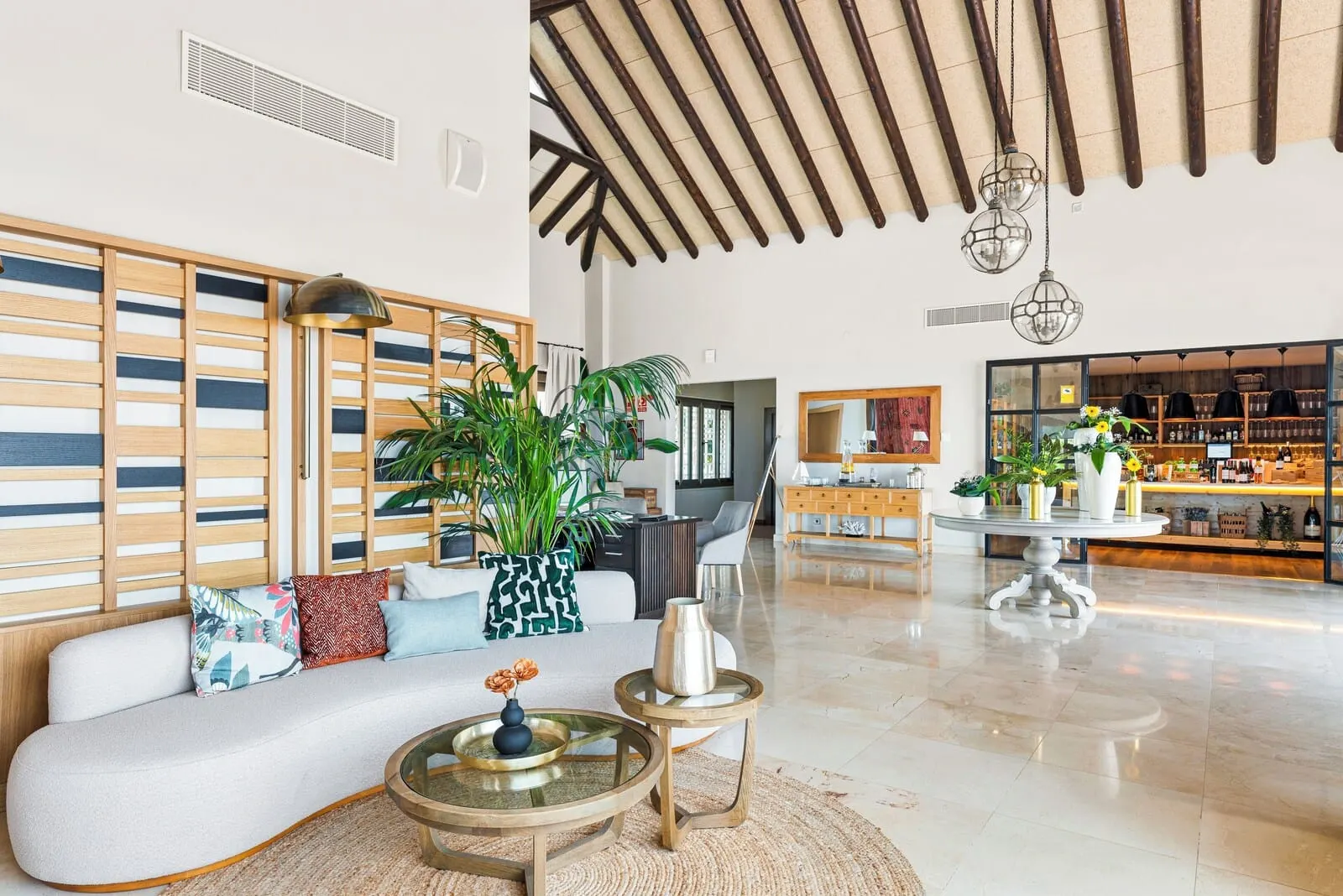 Las Terrazas de Abama Suites: A spacious living area with a modern sofa, a coffee table, and a large potted plant