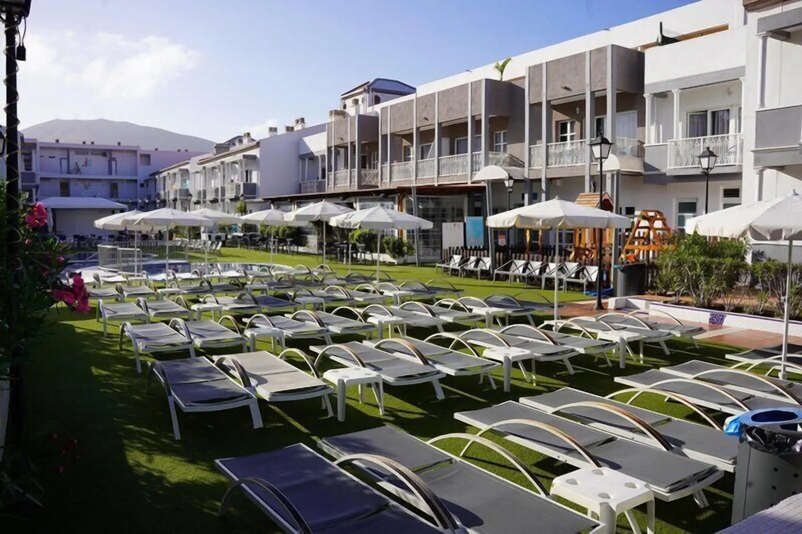Coral Compostela Beach Golf: A hotel courtyard with sun loungers, umbrellas, and a pool area