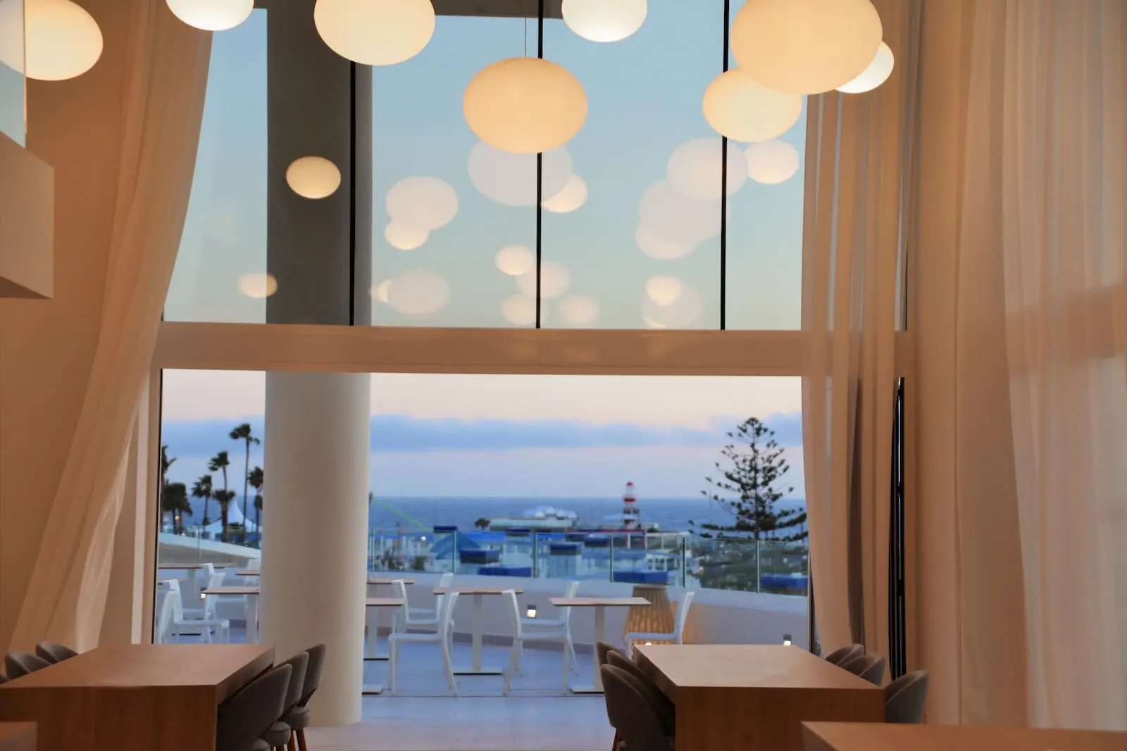 Iberostar Selection Sábila: A modern dining area with large windows overlooking a scenic view
