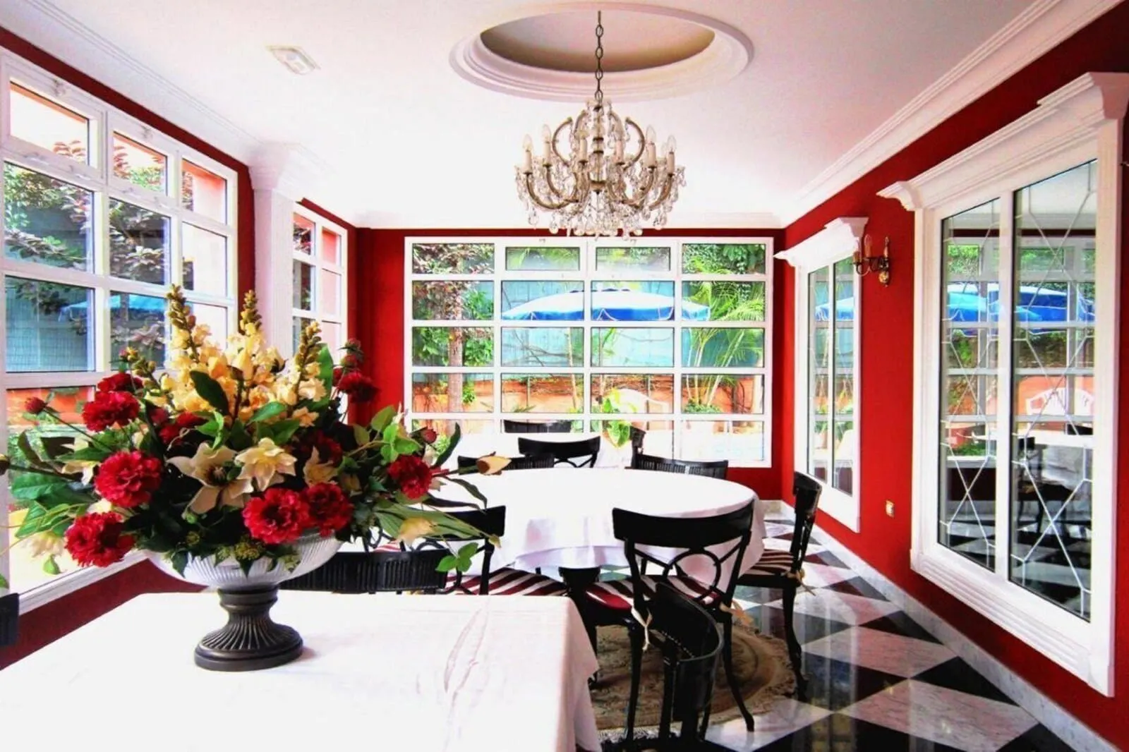 Hotel Don Cándido: A dining area with a chandelier, a table with a vase of flowers