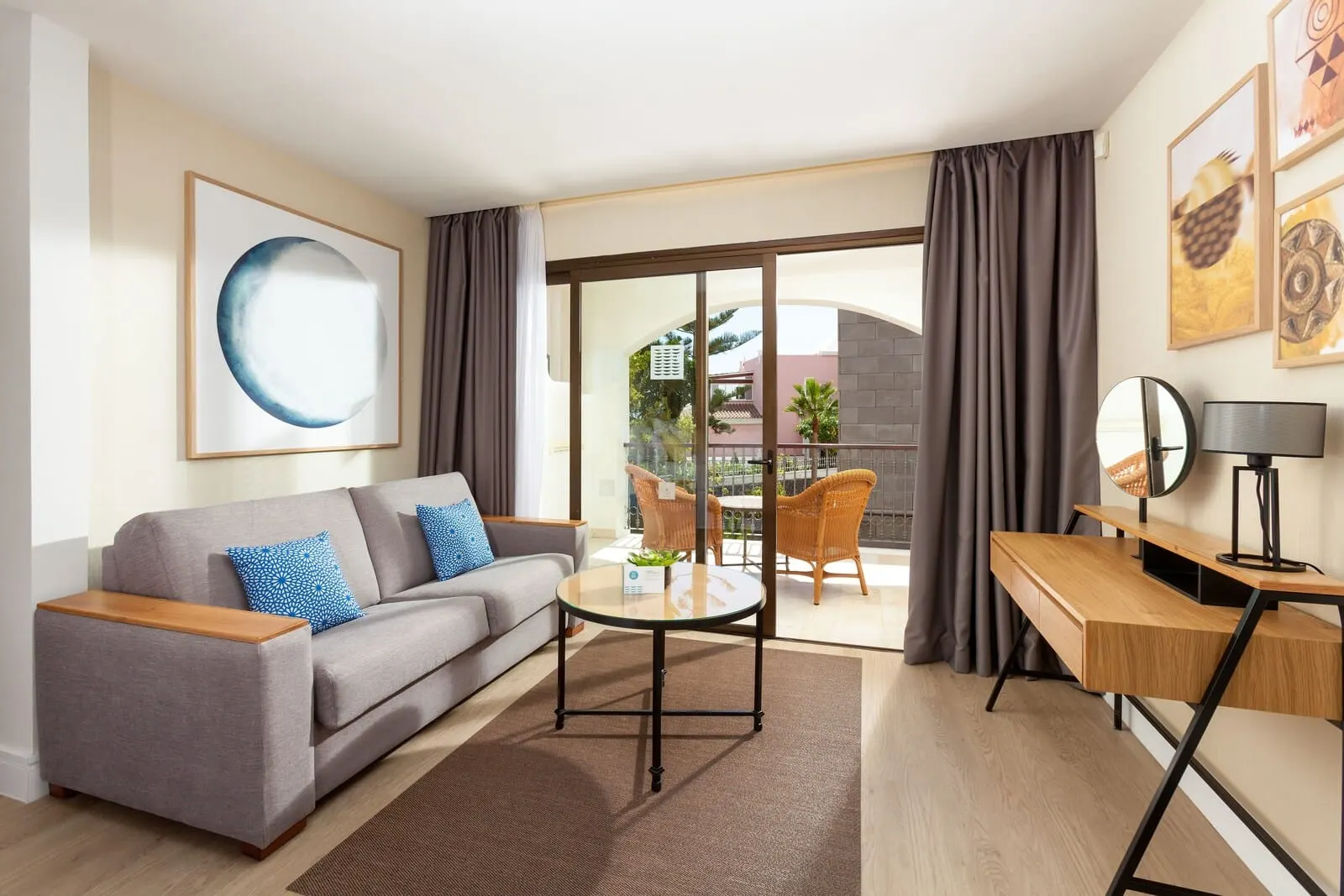 Gran Tacande Wellness & Relax: A modern living room with a grey sofa, a round coffee table, a wooden desk