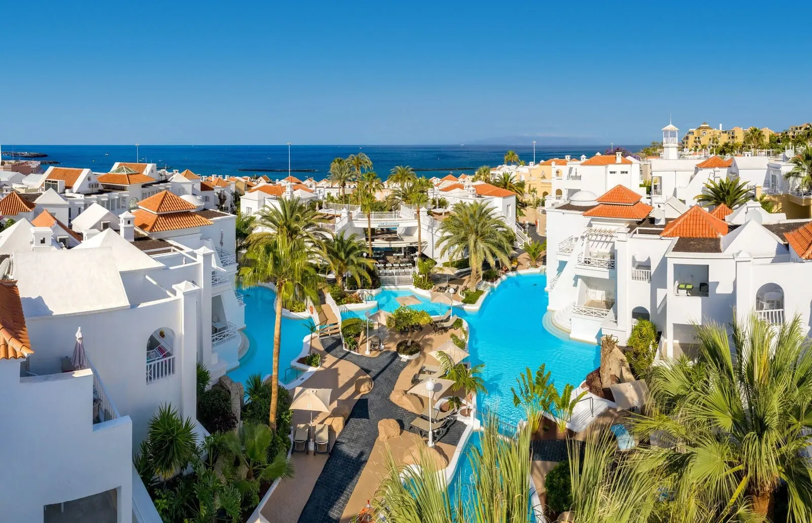 Lagos de Fañabé Beach Resort: A resort with a large pool, white buildings, and palm trees