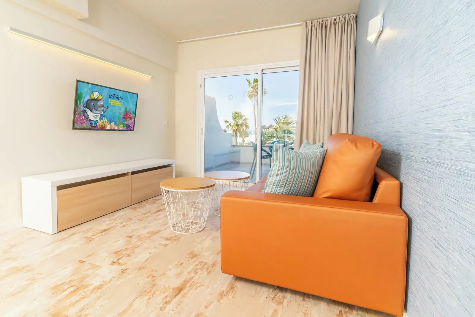 HOVIMA La Pinta Beachfront Family Hotel: A modern living room with a sofa, a bench, and a small table
