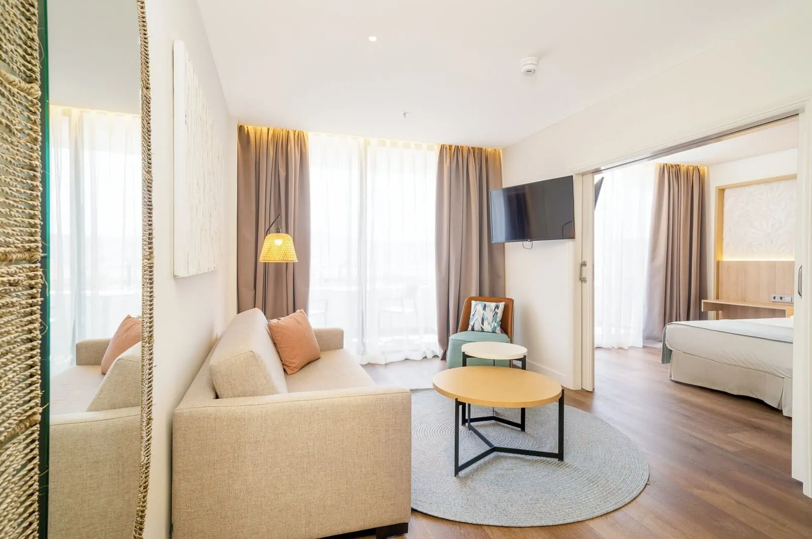 Mediterranean Palace: A modern living room with a sofa, a round coffee table, and a TV mounted on the wall