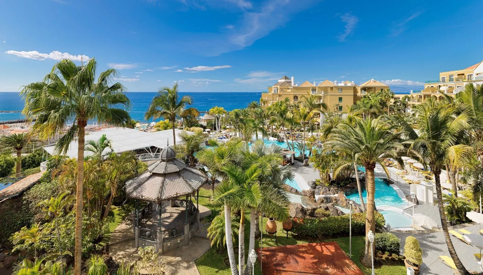 Hotel Jardines de Nivaria: A resort with a pool, palm trees, and a view of the ocean