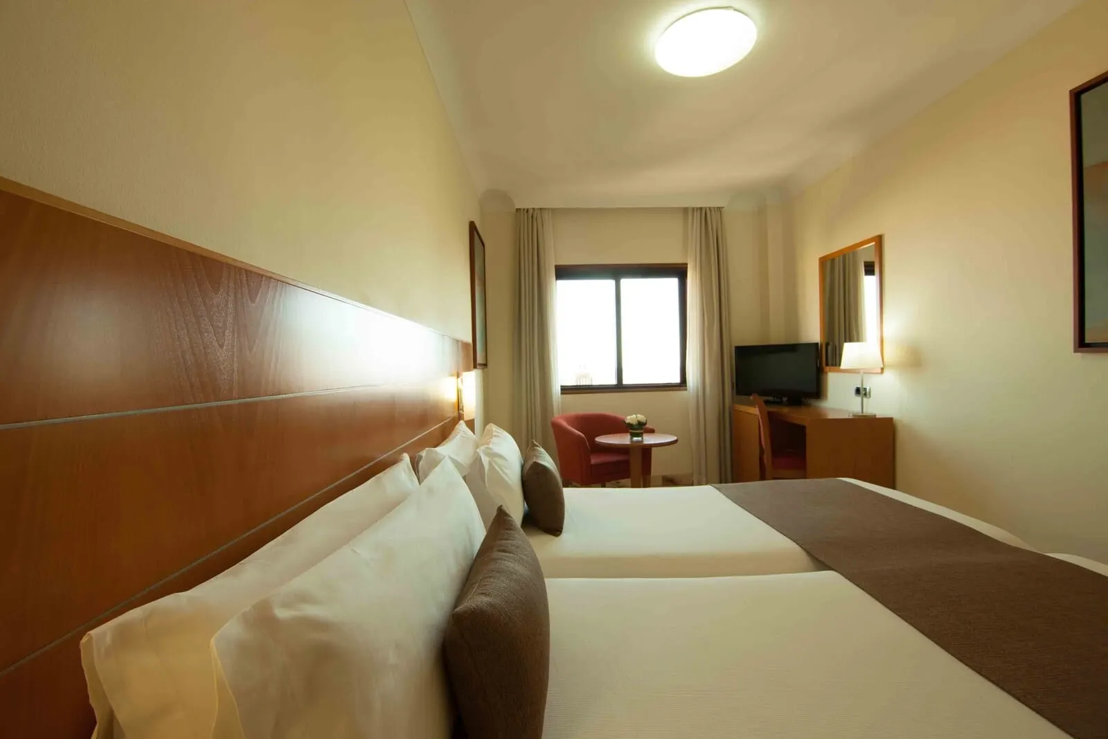 Hotel Príncipe Paz: A hotel room with two beds, a TV, a desk, and a chair