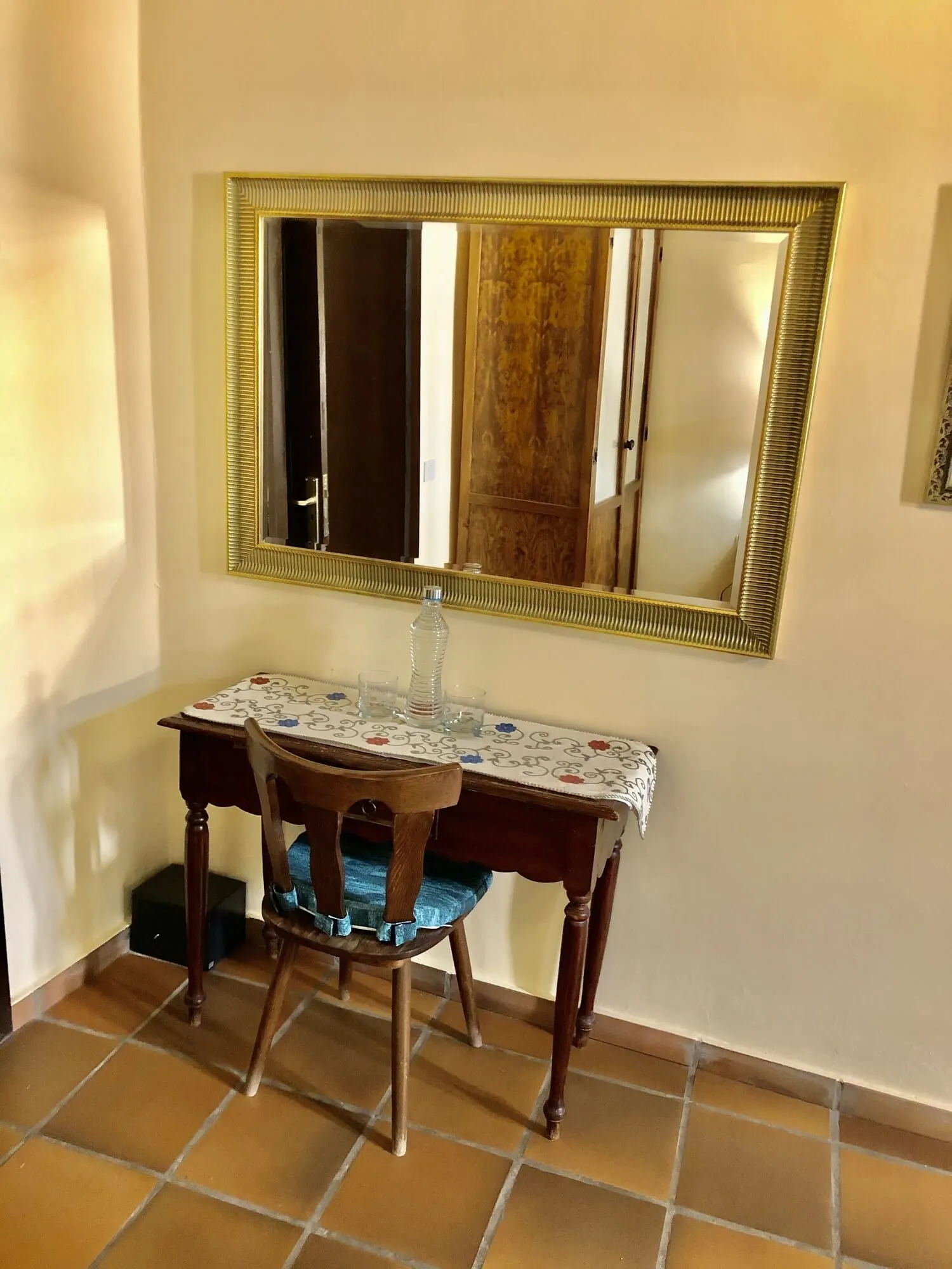 Hotel Rural Vilaflor: A dining area with a table set for two, a chair, a mirror, and a tiled floor