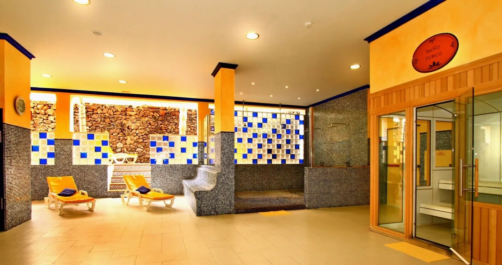 Park Club Europe: A spa area with two sun loungers, a stone wall