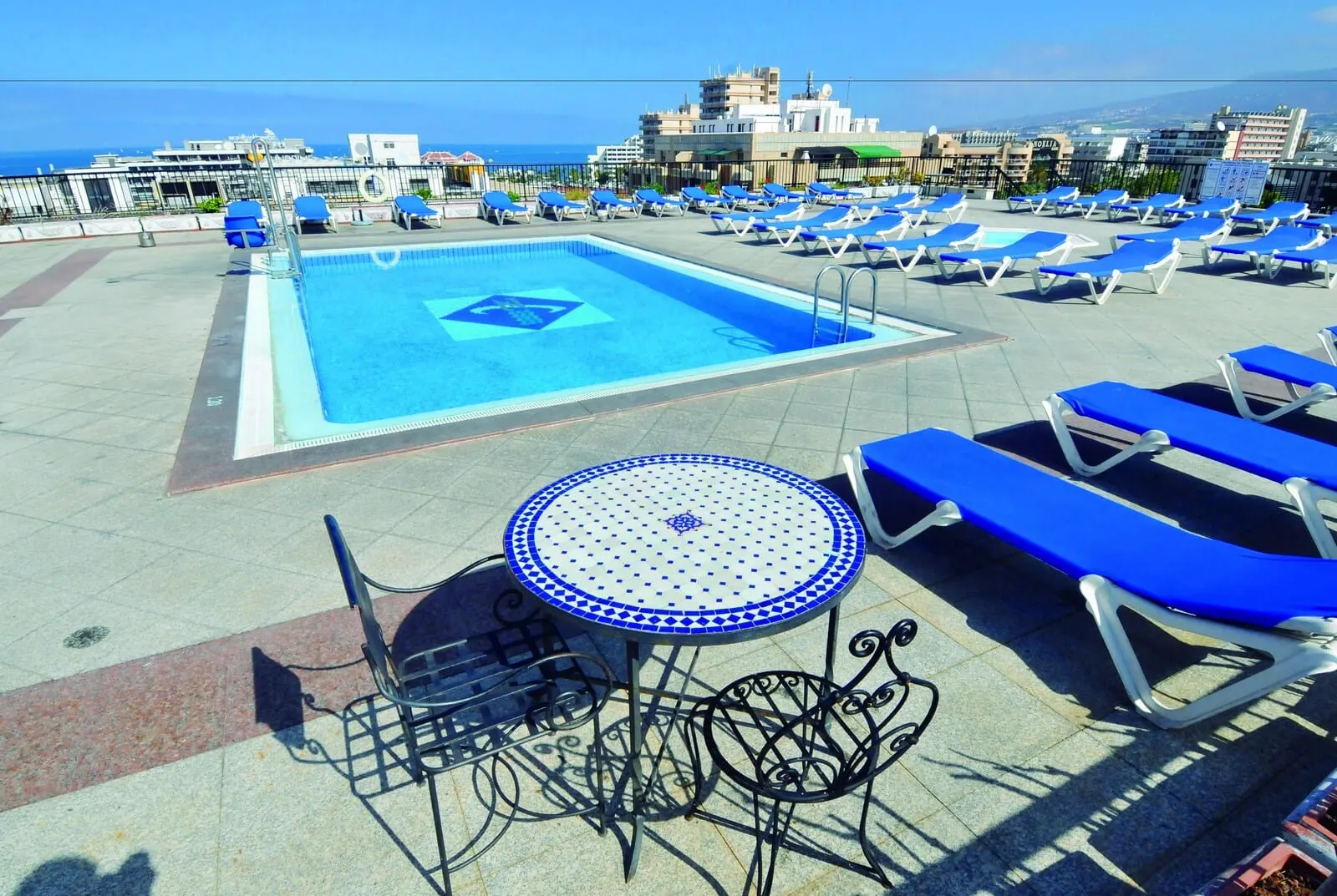 Hotel Zentral Center: A rooftop pool area with blue lounge chairs and a small table