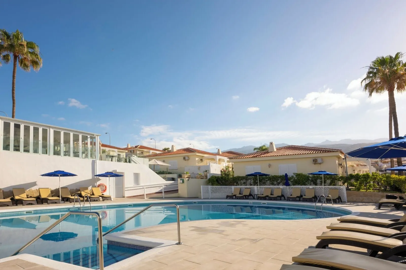 Ona Sueño Azul: A pool area with lounge chairs and umbrellas