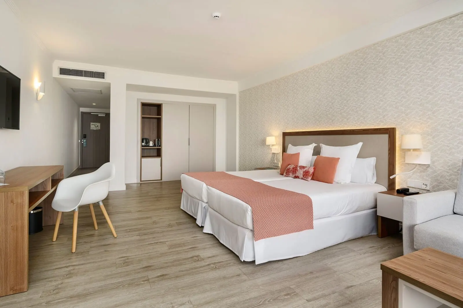 Alua Atlántico Golf Resort: A hotel room with a bed, bedside tables, a desk, and a chair