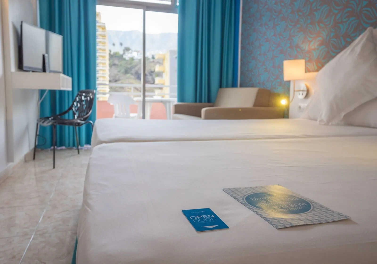 Checkin Concordia Playa: A hotel room with a bed, a chair, a sofa, and a TV on a stand