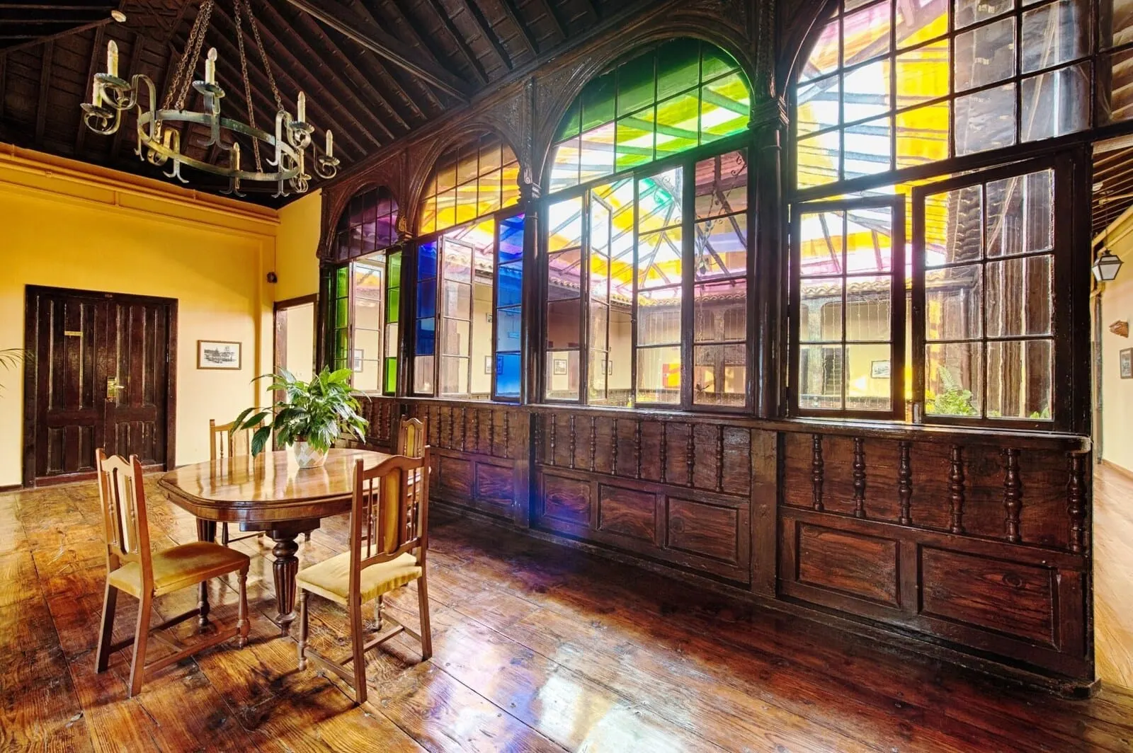Marquesa Hotel: A dining area with a wooden table and chairs, large windows with stained glass