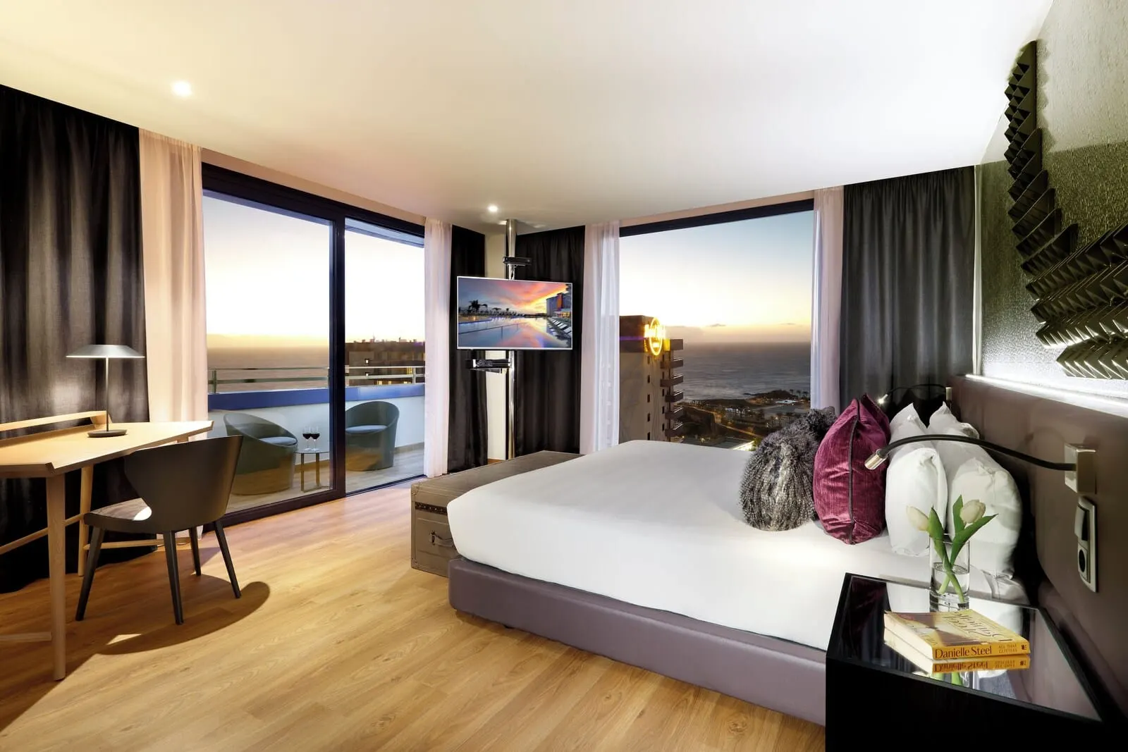 Hard Rock Hotel Tenerife: A modern hotel room with a large bed, a desk, a chair, and a TV