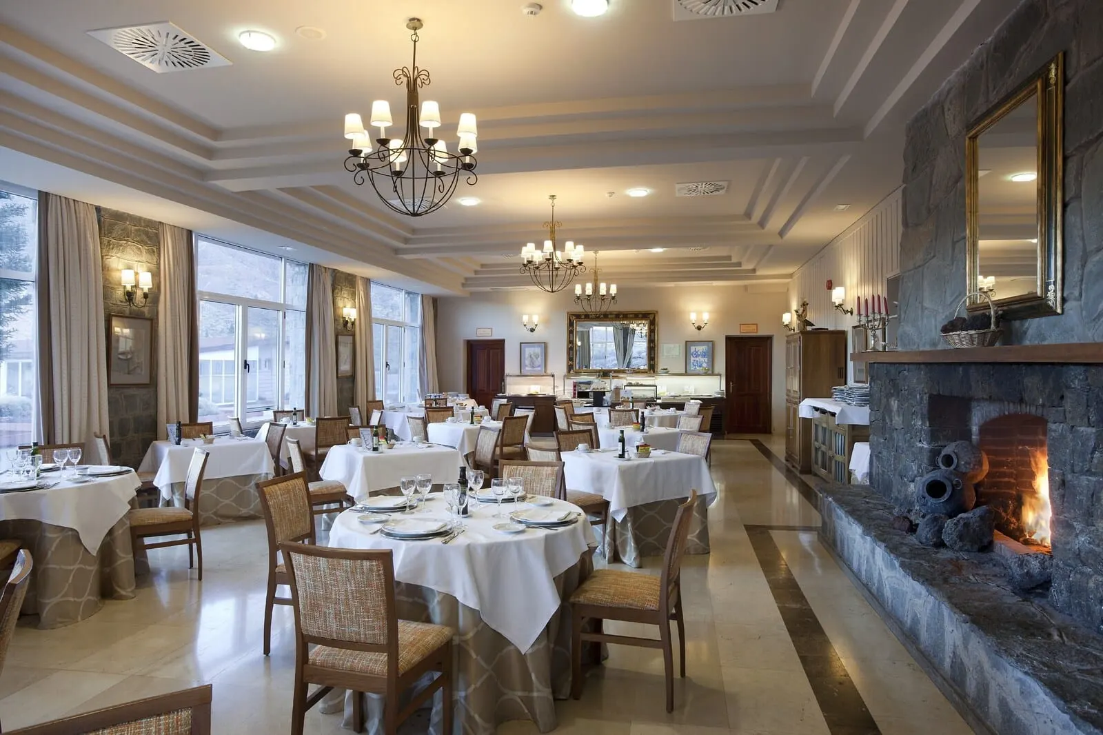 Parador de Las Cañadas del Teide: A spacious dining area with multiple tables set for dining, a stone fireplace