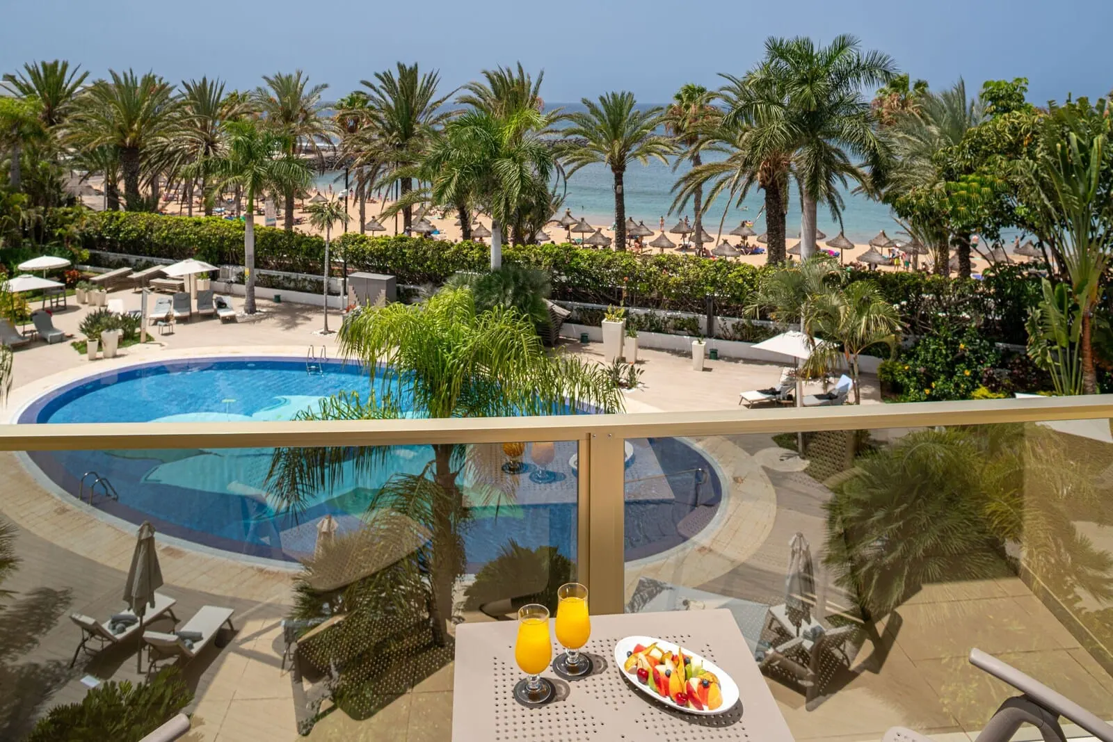 Sir Anthony: A poolside view with a pool, lounge chairs, and a table with drinks and fruit