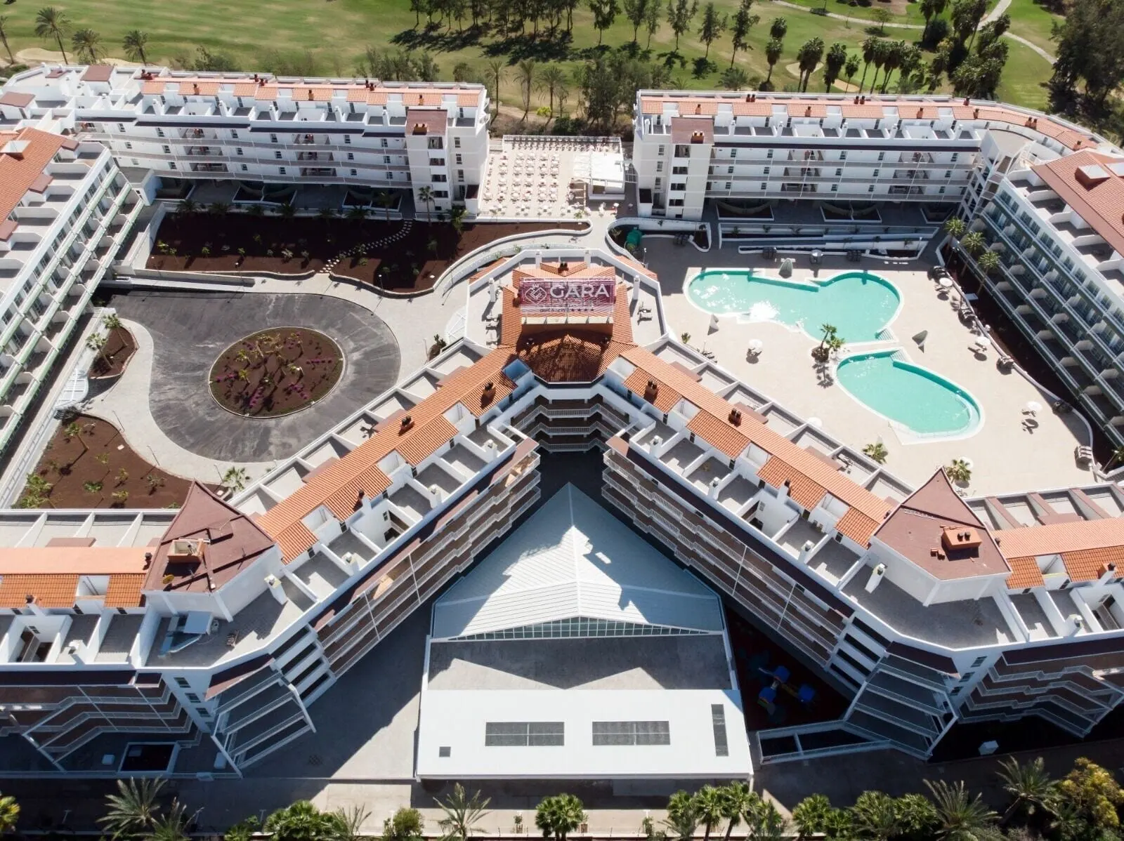 Gara Suites Golf & Spa: A modern hotel with a central courtyard, multiple swimming pools