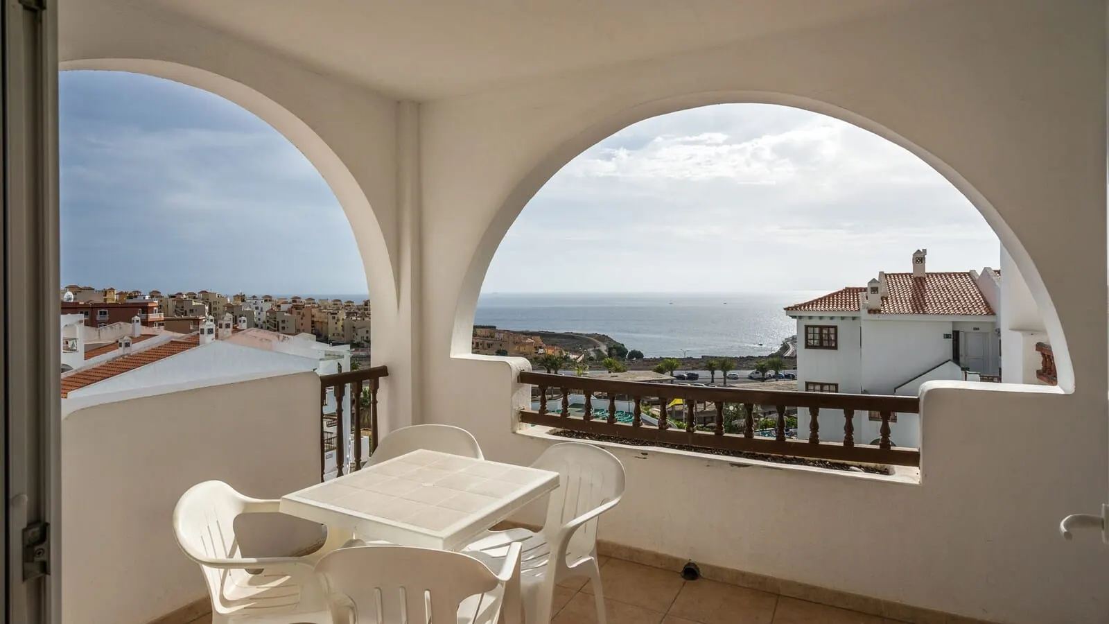 BLUESEA Callao Garden: A balcony with a table and chairs, overlooking a coastal town and the sea