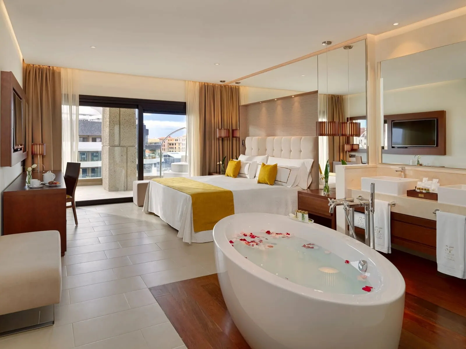 GF Victoria: A modern hotel room with a large bed, a sitting area with a desk