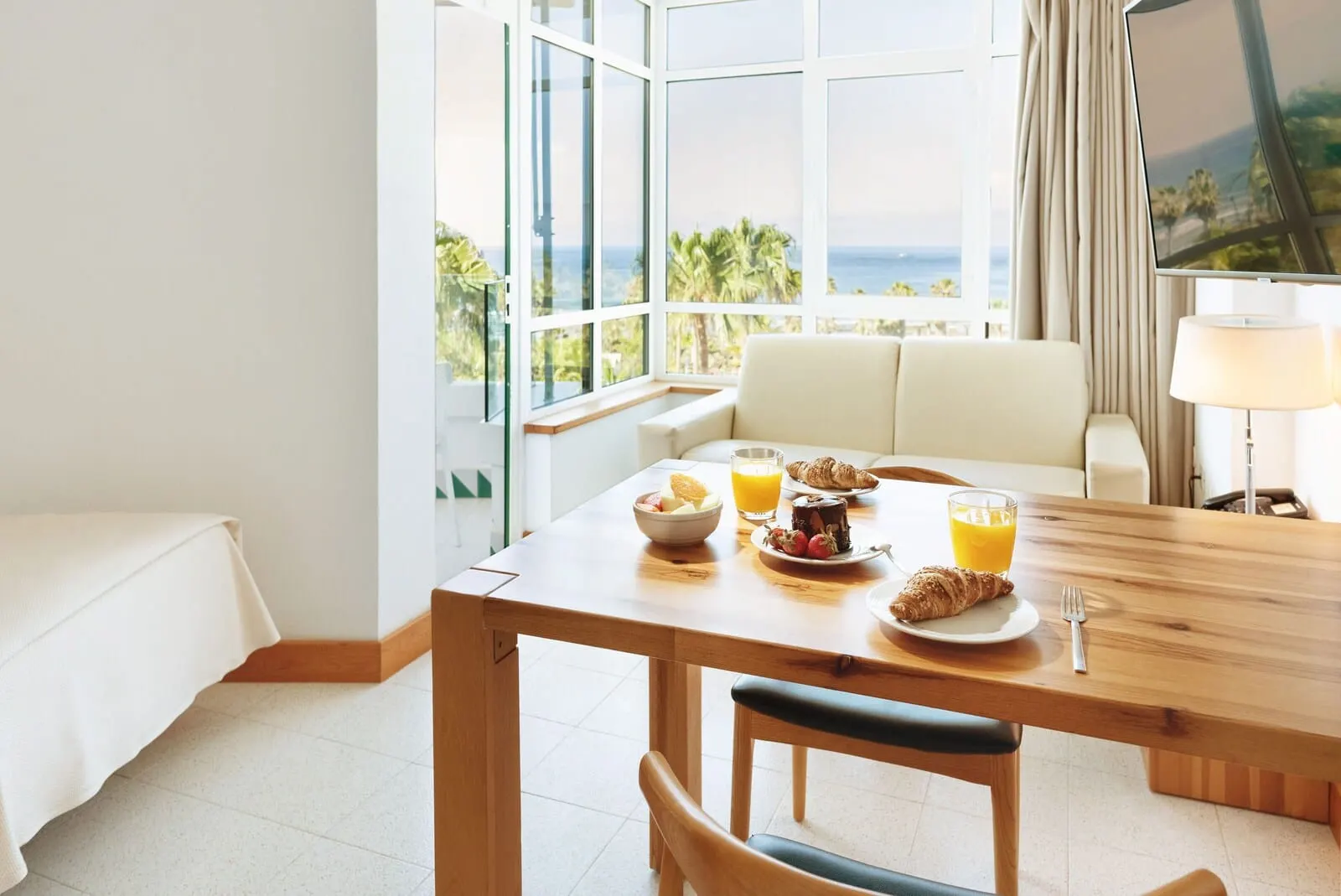 Parque Santiago IV: A breakfast table with croissants, fruit, and orange juice, a sofa
