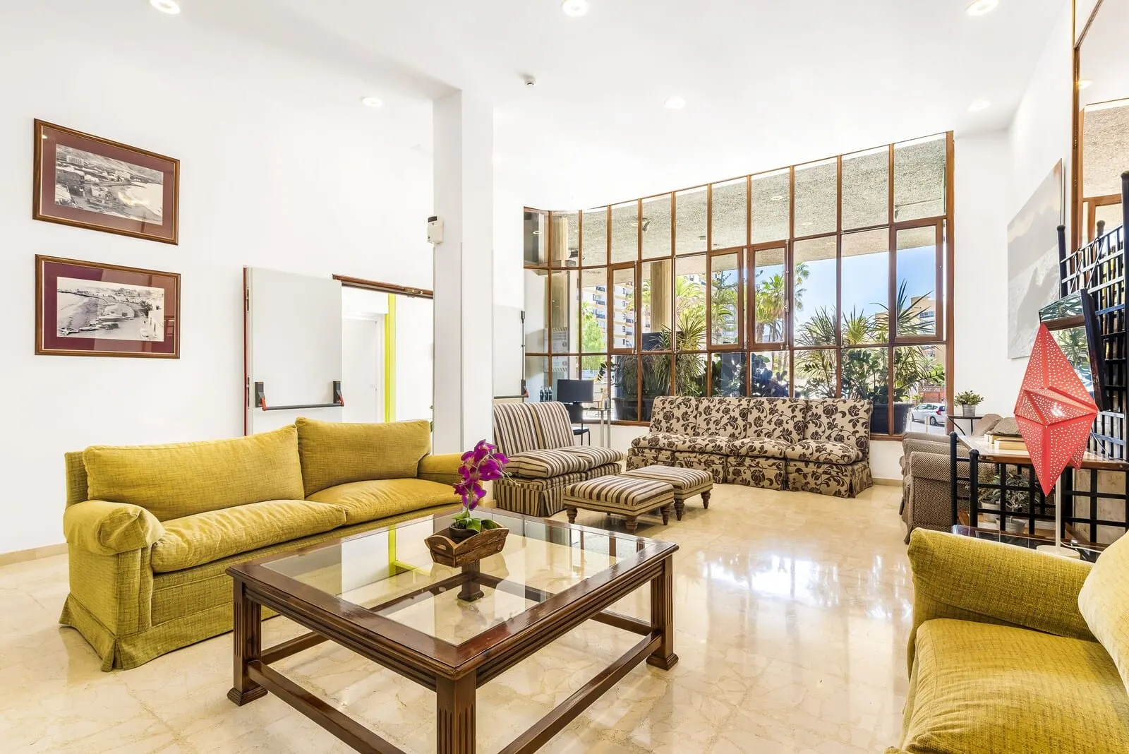Andrea's Hotel Tenerife: A spacious living room with a yellow sofa, striped armchairs, and a glass coffee table