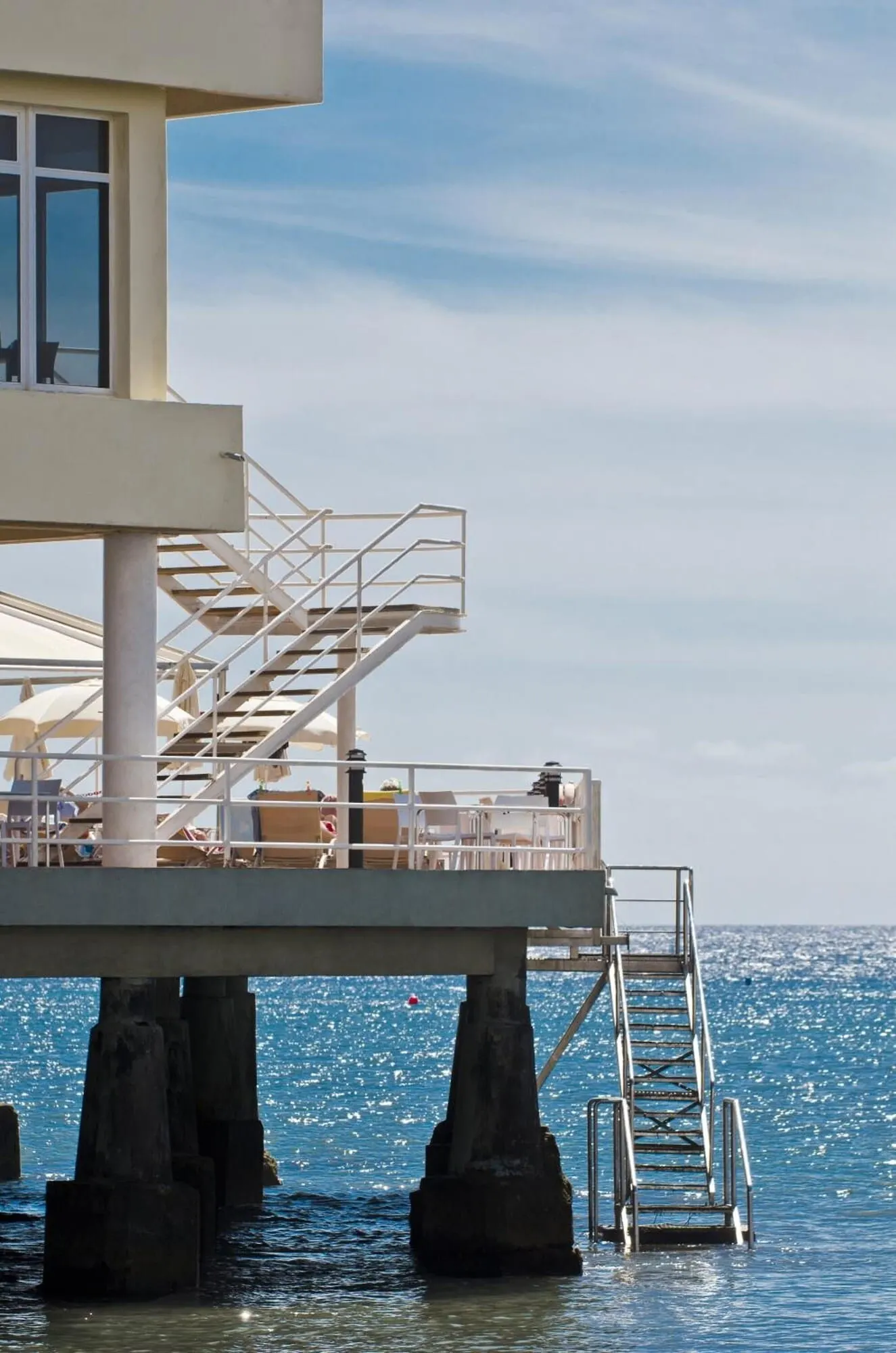 Médano Hotel: A pier with a staircase leading to a deck area with seating and tables