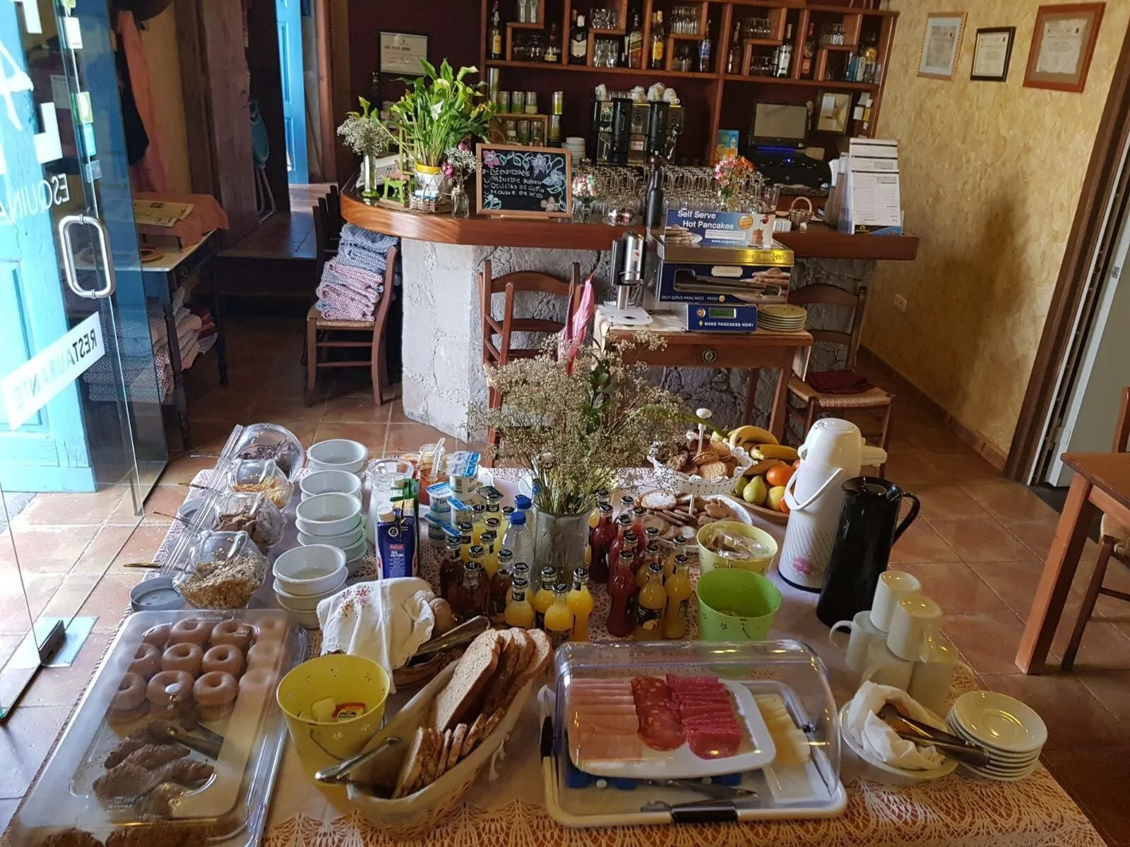 Hotel Cuatro Esquinas: A breakfast buffet with various food items, including pastries, bread, and meats
