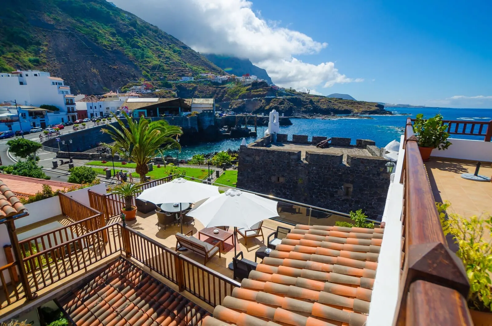 Garahotel: A coastal town with terracotta-tiled rooftops, outdoor seating, and a view of the sea