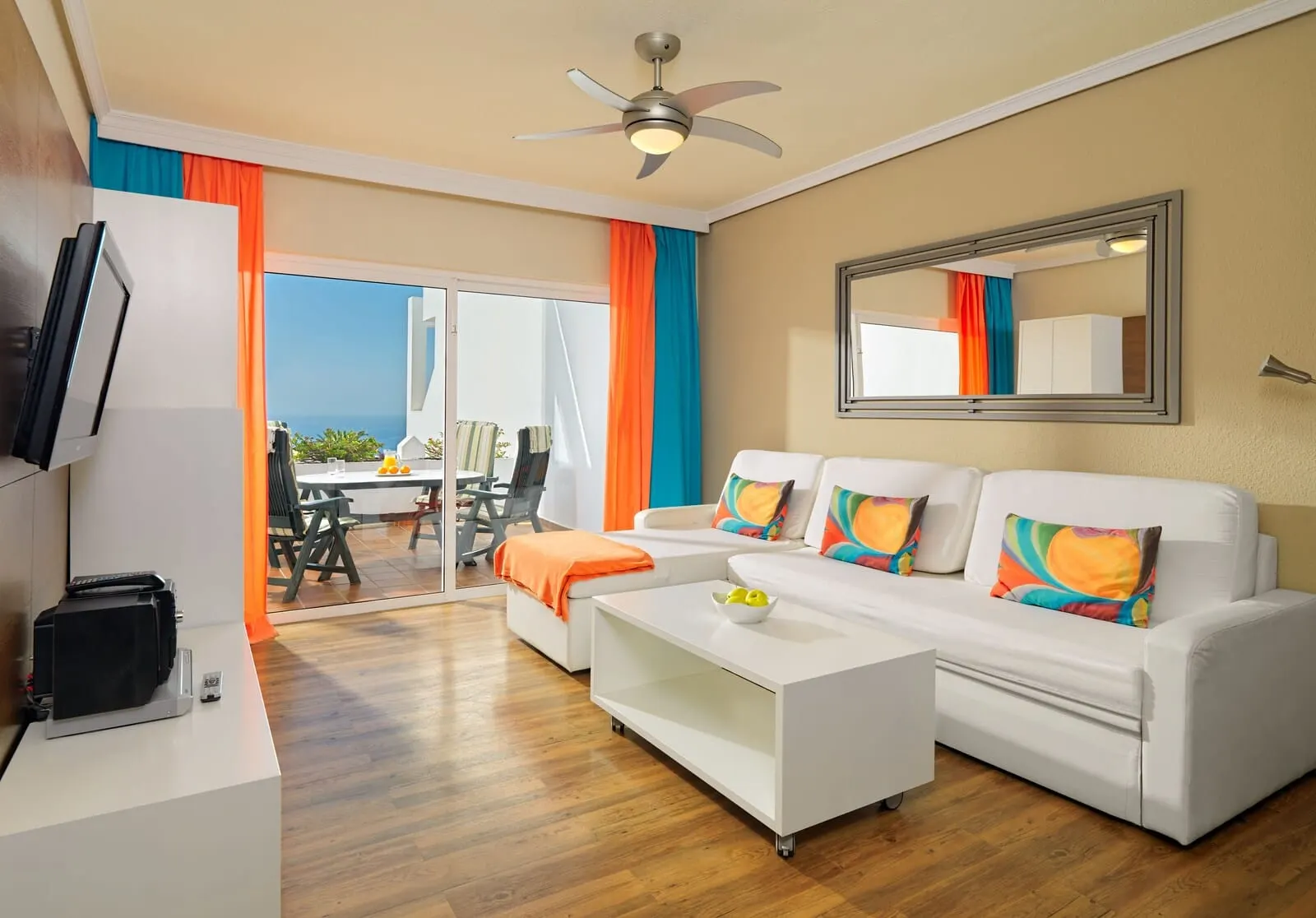 Regency Torviscas Apartments & Suites: A modern living room with a white sofa set, a coffee table, and a flat-screen TV
