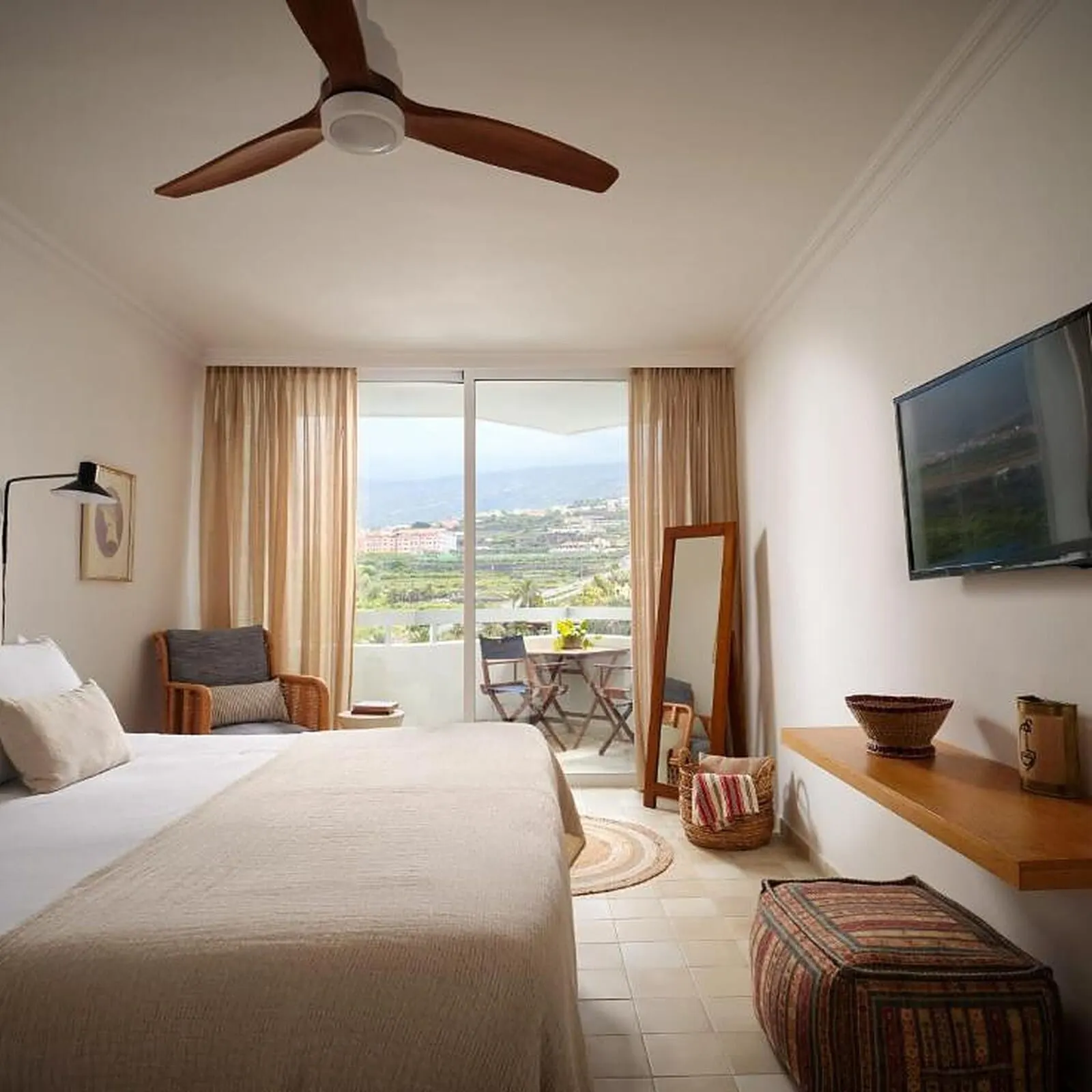 Precise Resort Tenerife: A hotel room with a bed, a ceiling fan, a TV, a balcony with a table and chairs