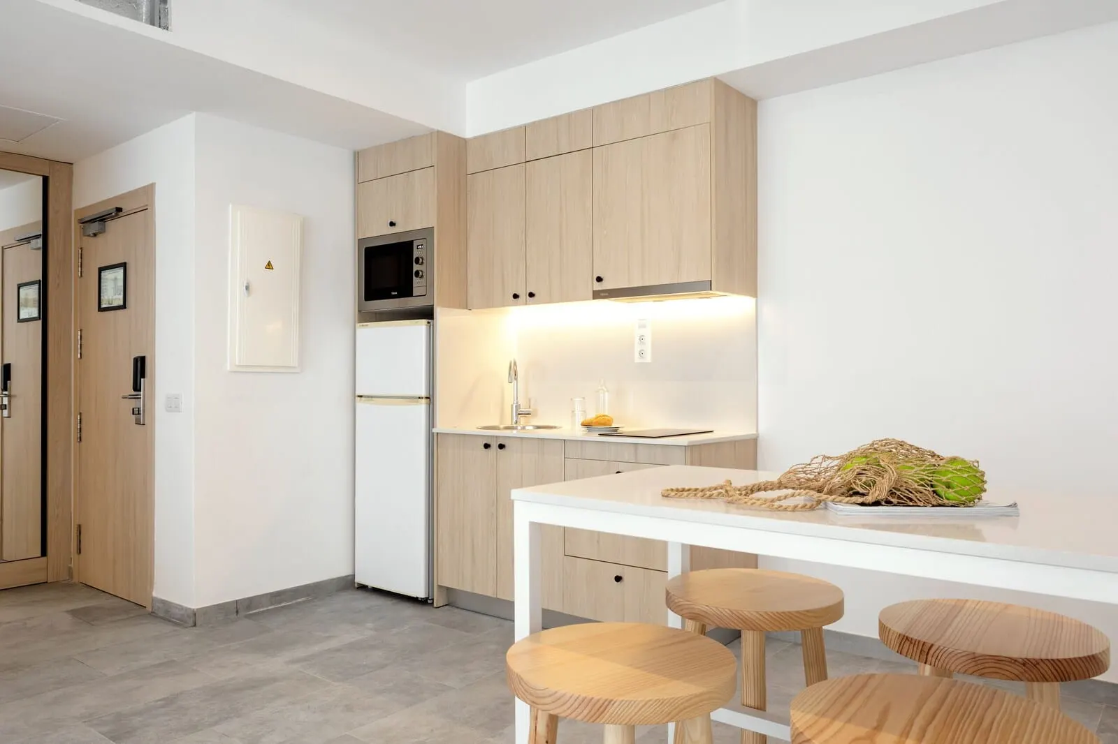 Sunwing Fañabé Beach: A modern kitchen with wooden cabinets, a white countertop