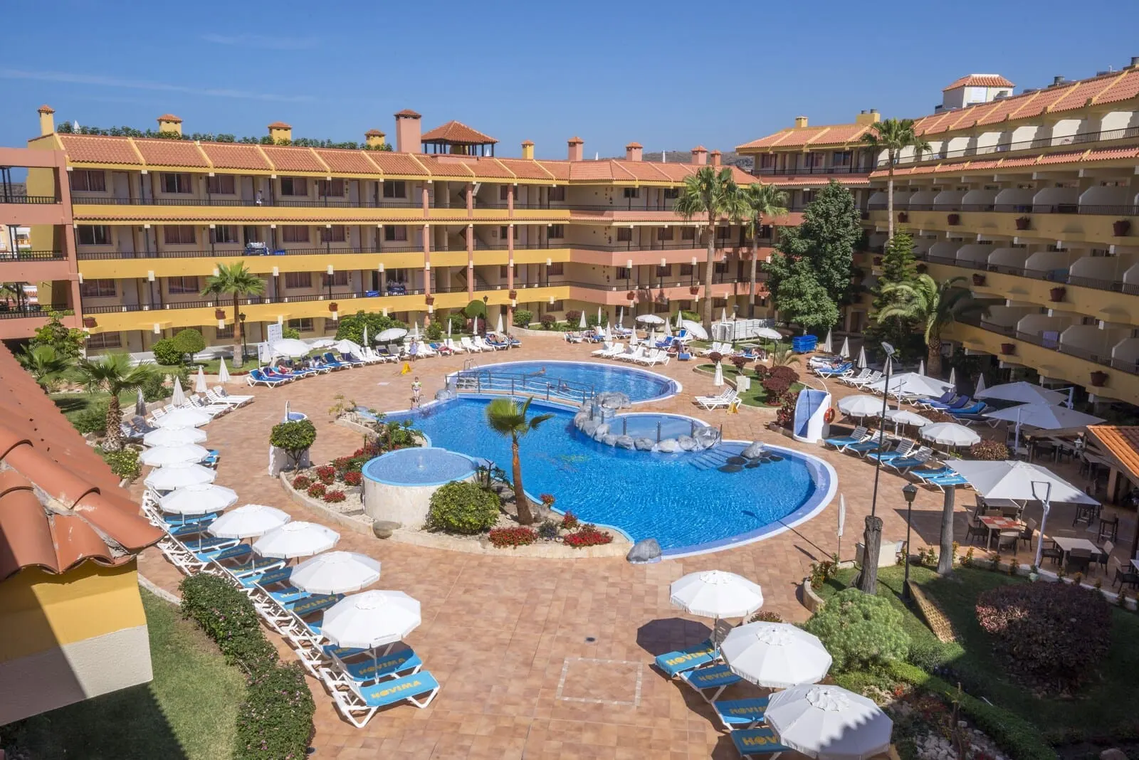 HOVIMA Jardín Caleta: A hotel with multiple swimming pools, sun loungers, and umbrellas