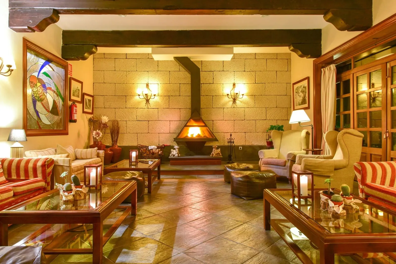 Hotel Spa Villalba: A cozy living room with a fireplace, comfortable seating, and decorative elements