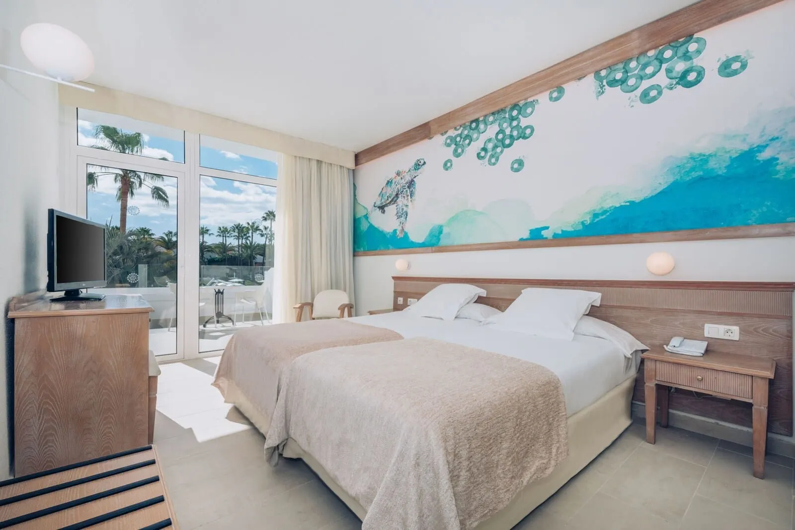 Iberostar Waves Las Dalias: A hotel room with two beds, a TV, a desk, and a large window with a view of palm trees