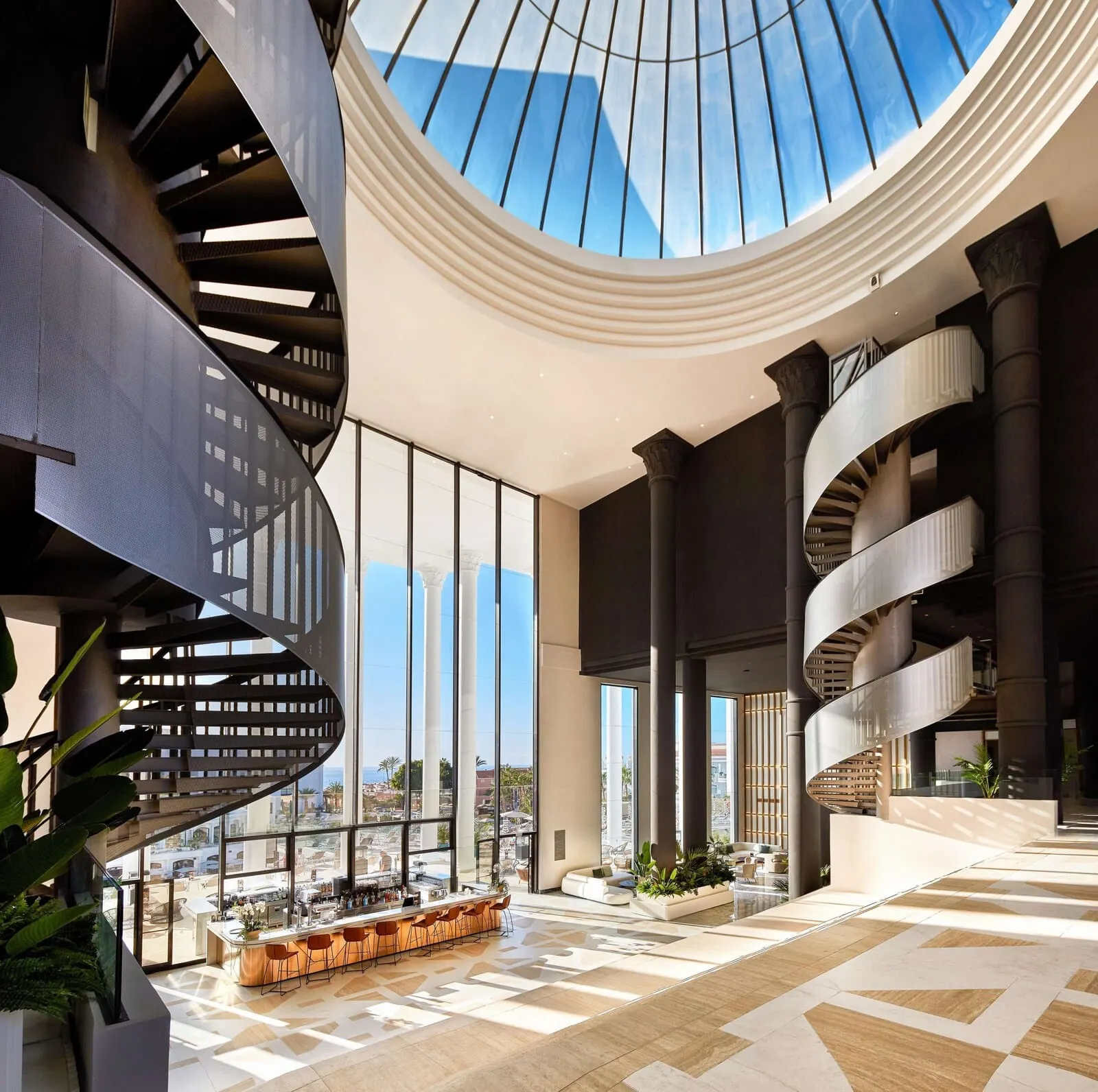 Princess Inspire Tenerife: A modern interior with a central spiral staircase, large windows, and a bar area