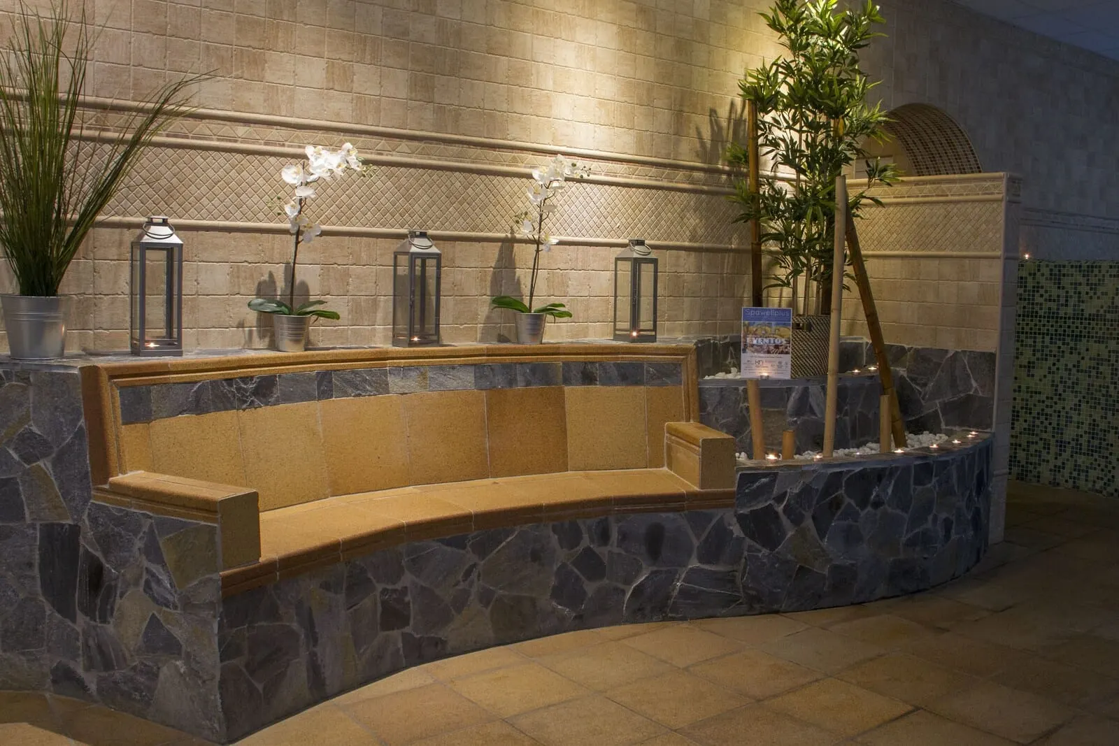 Best Semiramis: A stone bench with a planter, potted plants, and lanterns against a tiled wall