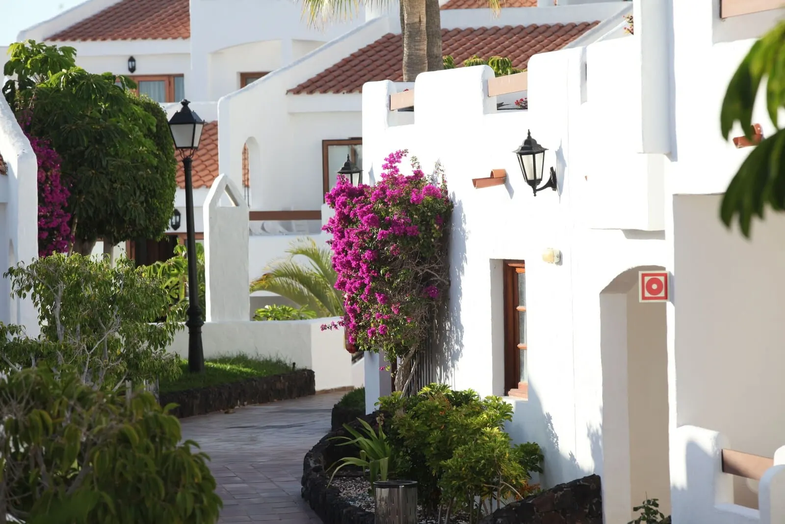 Ona Beverly Hills Suites: A narrow pathway flanked by white buildings with terracotta roofs