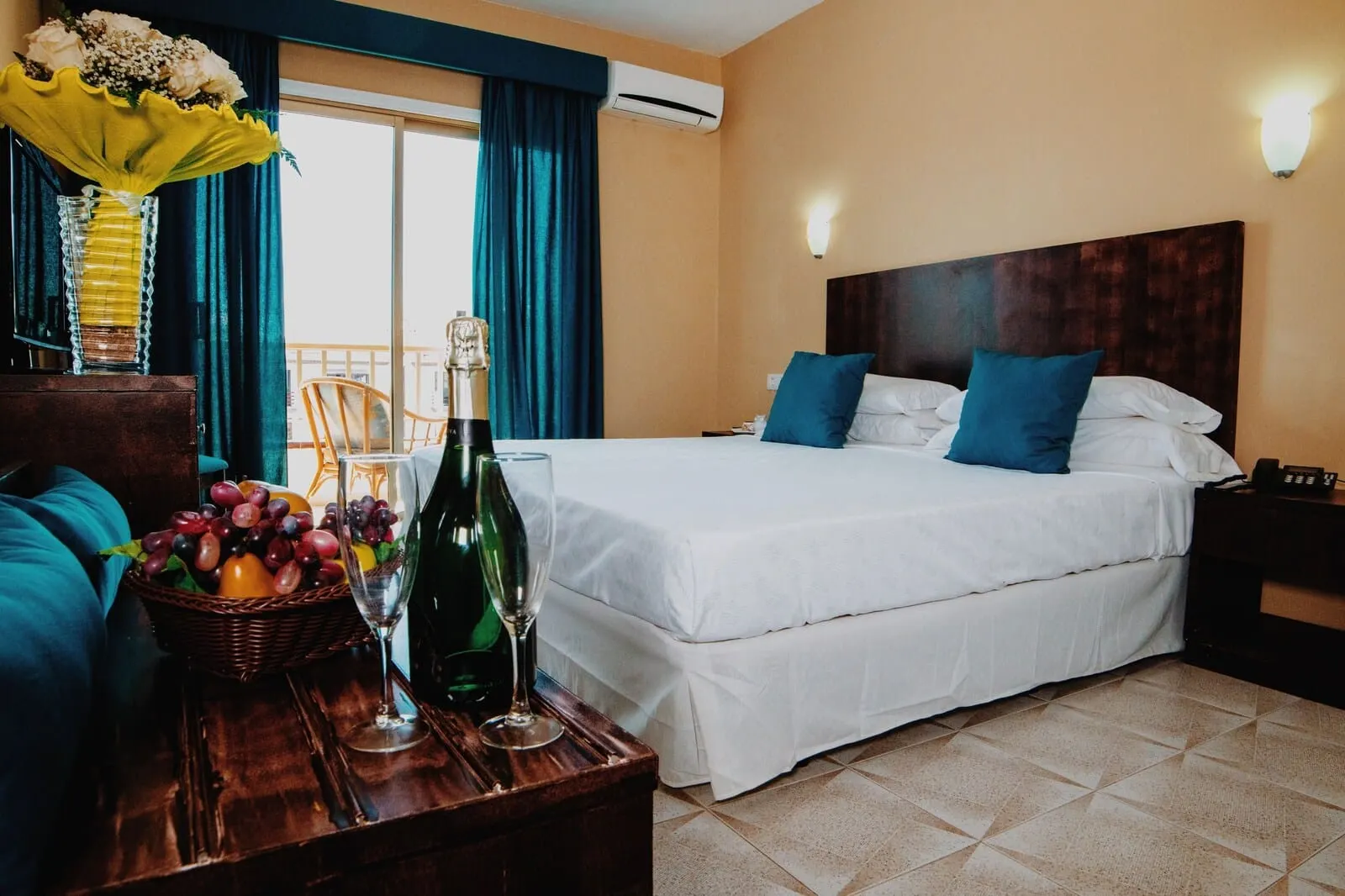 Hotel Aeropuerto Sur: A hotel room with a bed, a nightstand, a table with a bottle and glasses, a chair