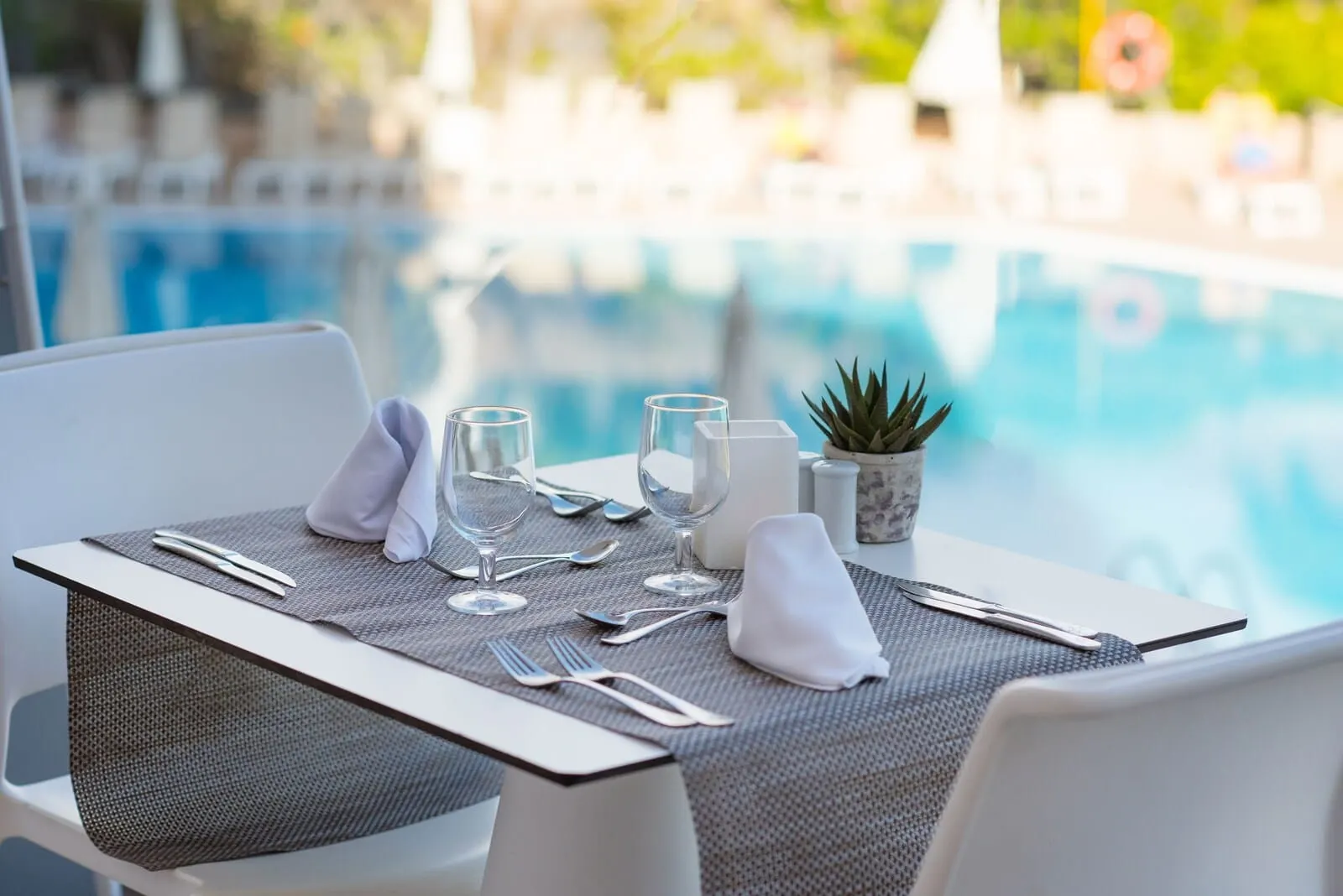 Iberostar Waves Bouganville Playa: A dining table set for two with a view of a swimming pool