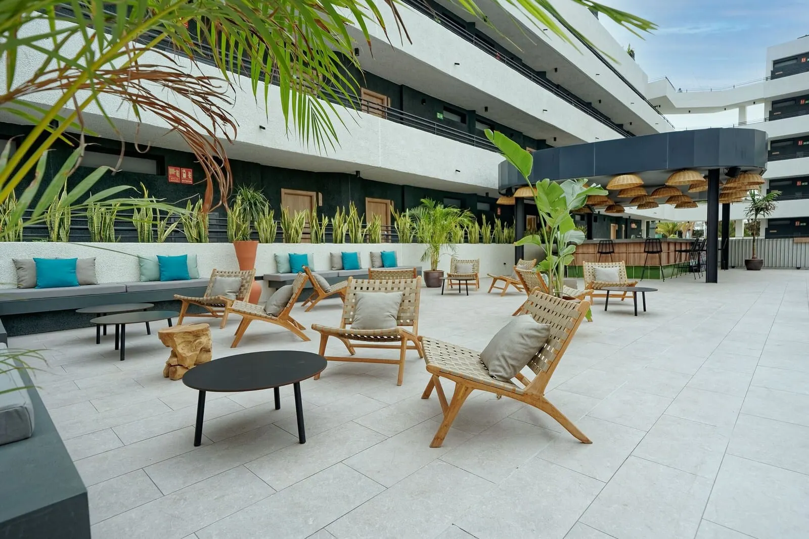 HOVIMA Suites Costa Adeje: A spacious outdoor seating area with wicker furniture and potted plants