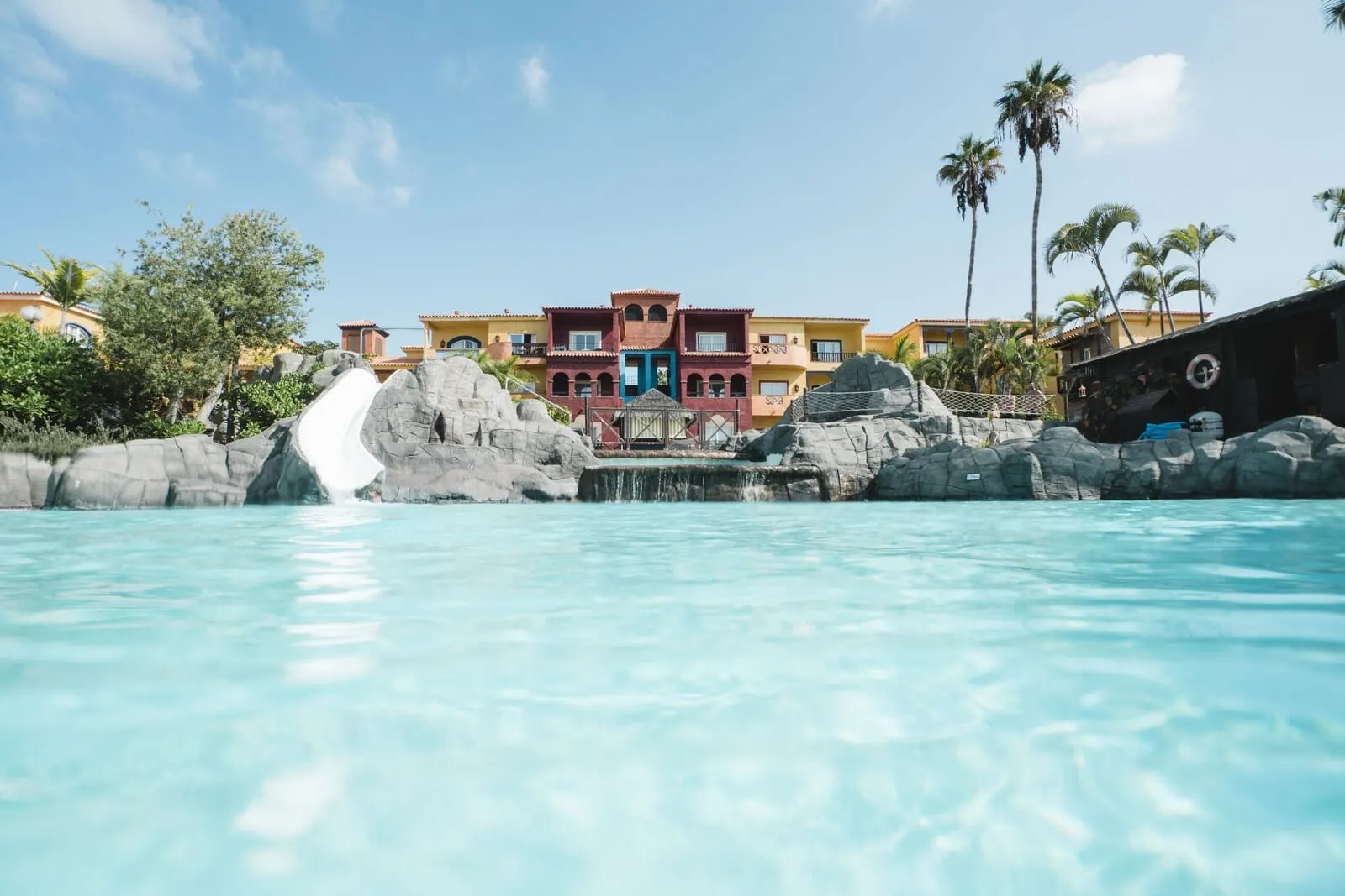 Park Club Europe: A pool with a waterfall, palm trees