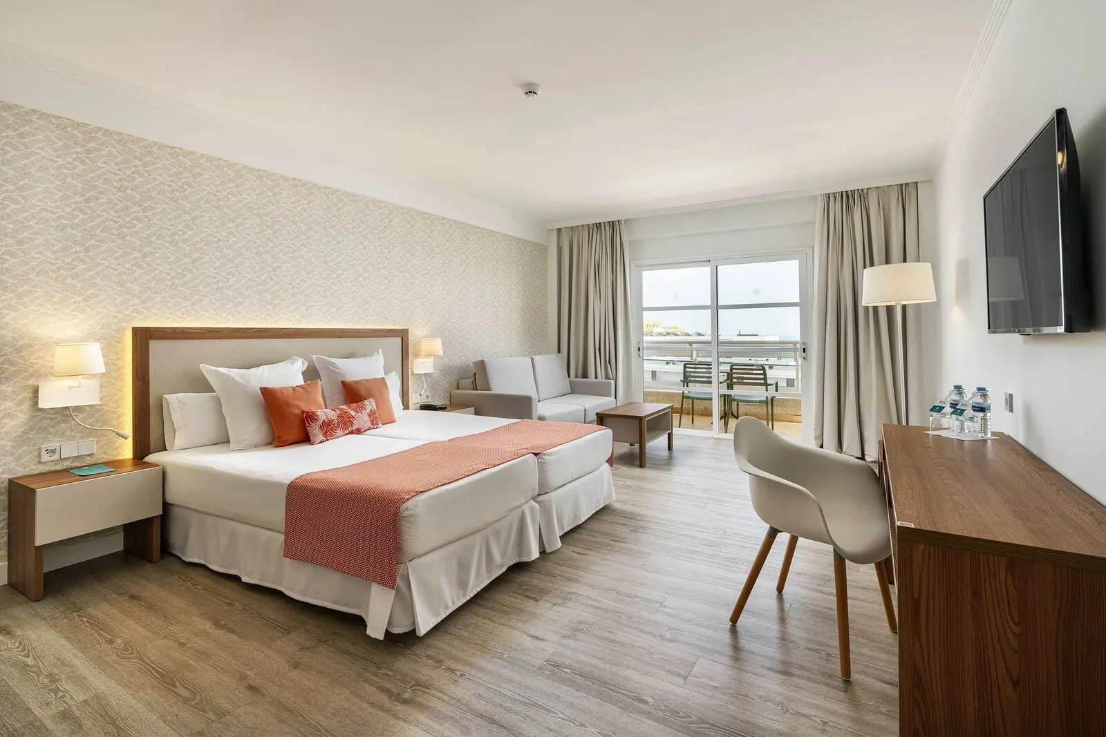 Alua Atlántico Golf Resort: A hotel room with a bed, bedside tables, a desk, a chair, and a TV