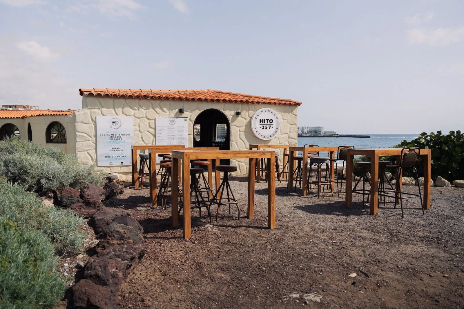 Playa Surf CBbC Hotel: A rustic stone building with a tiled roof, outdoor seating with stools and tables