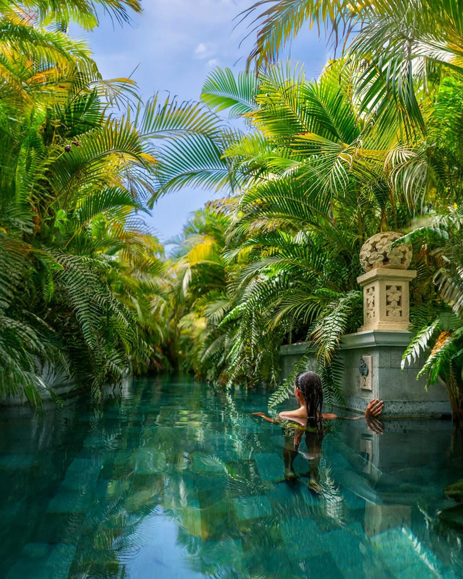 Royal River: A pool surrounded by lush palm trees and a stone structure with a spherical top