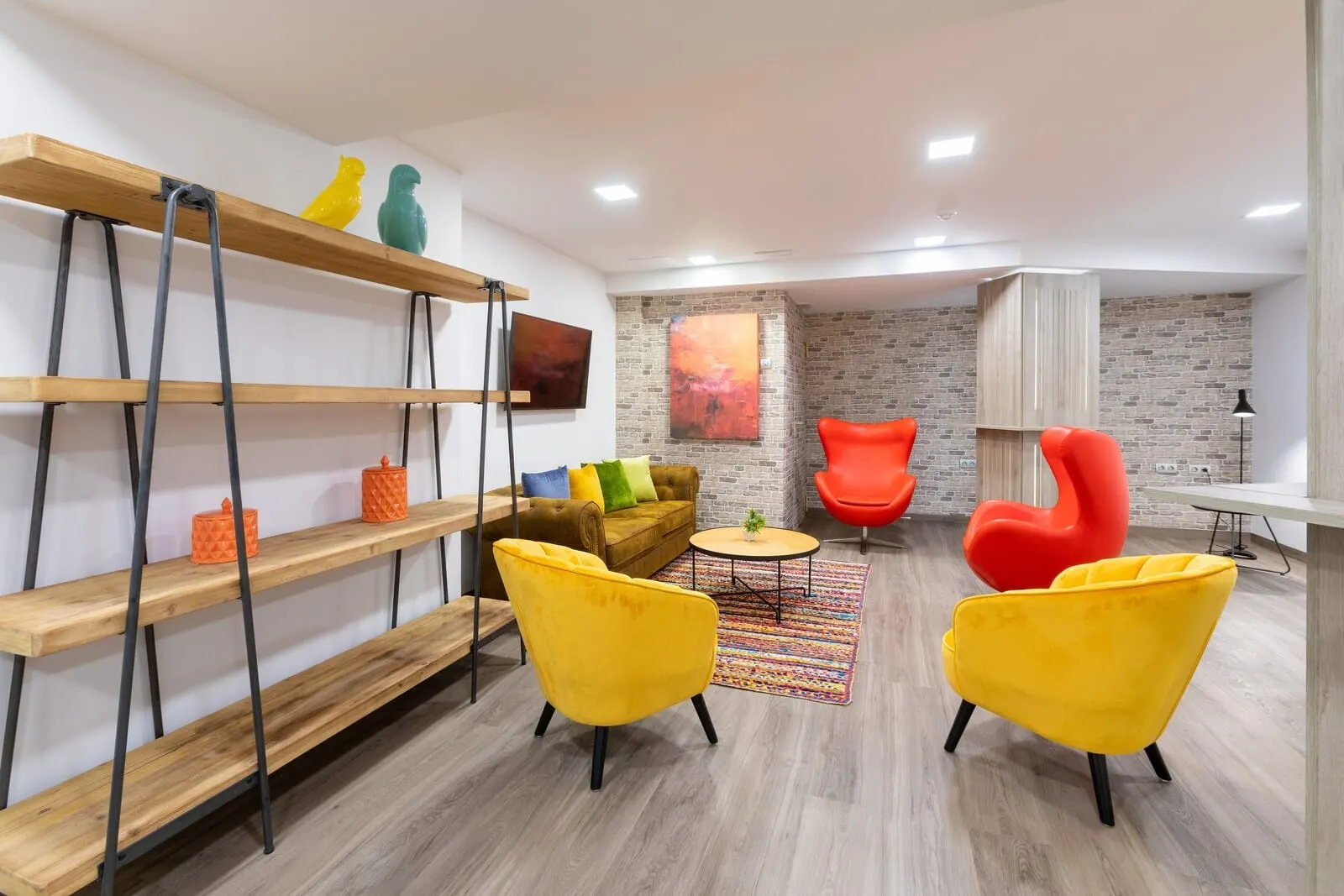 Alexandre Gala: A modern living room with wooden shelves, a sofa, two yellow armchairs, a red chair