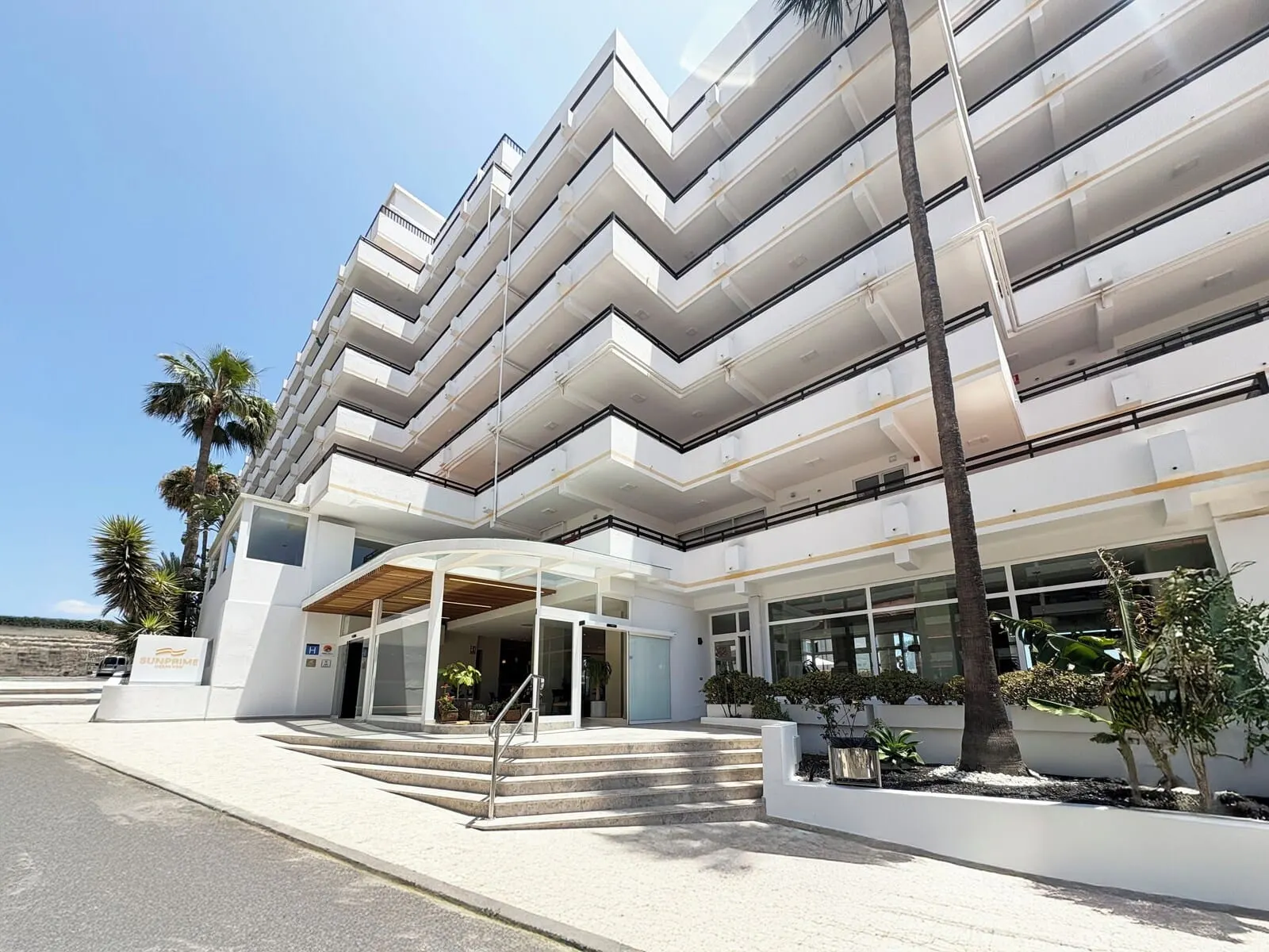 Coral Ocean View: A modern multi-story building with a curved entrance and a staircase leading to