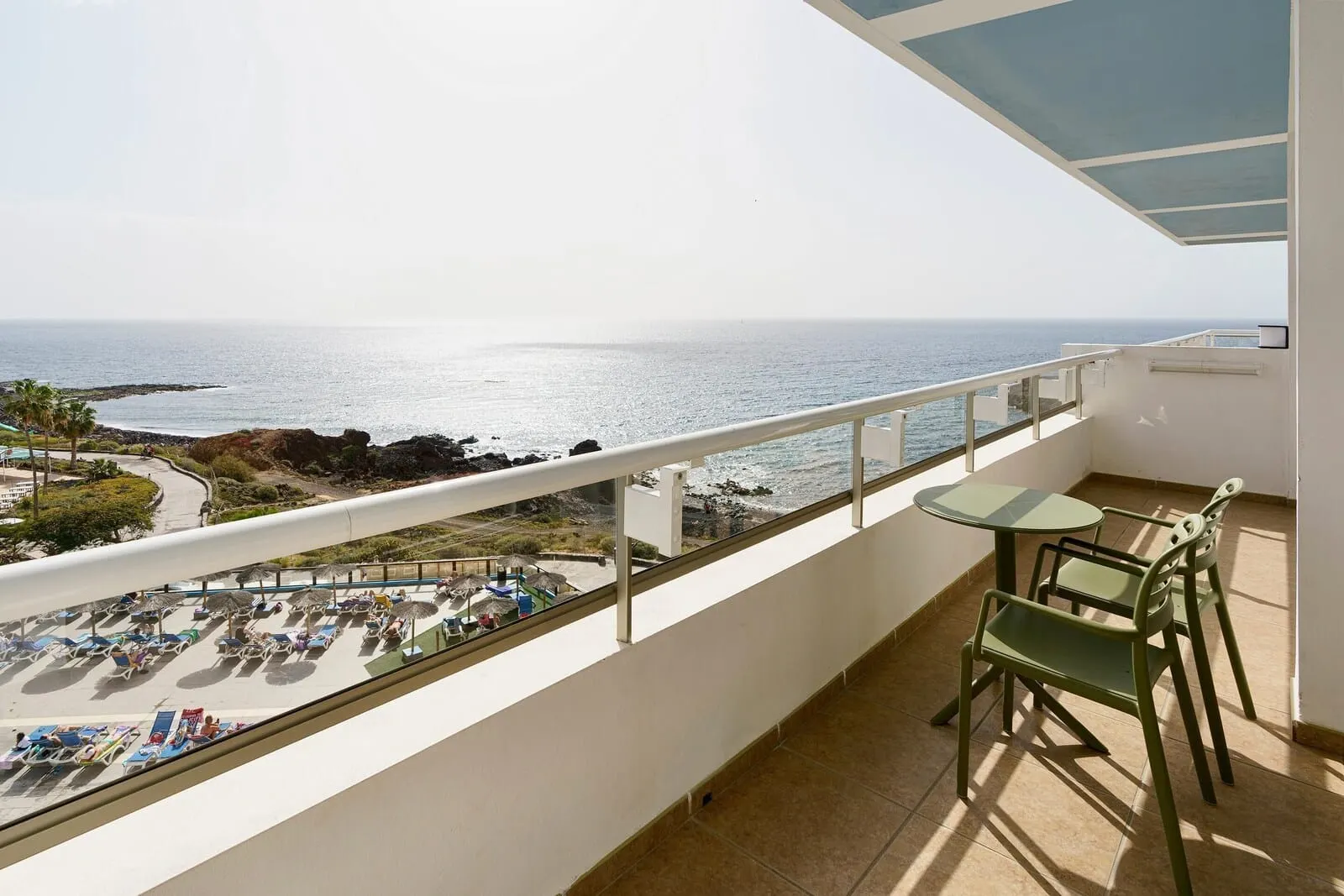 Alua Atlántico Golf Resort: A balcony with a view of the ocean, a table, and two chairs